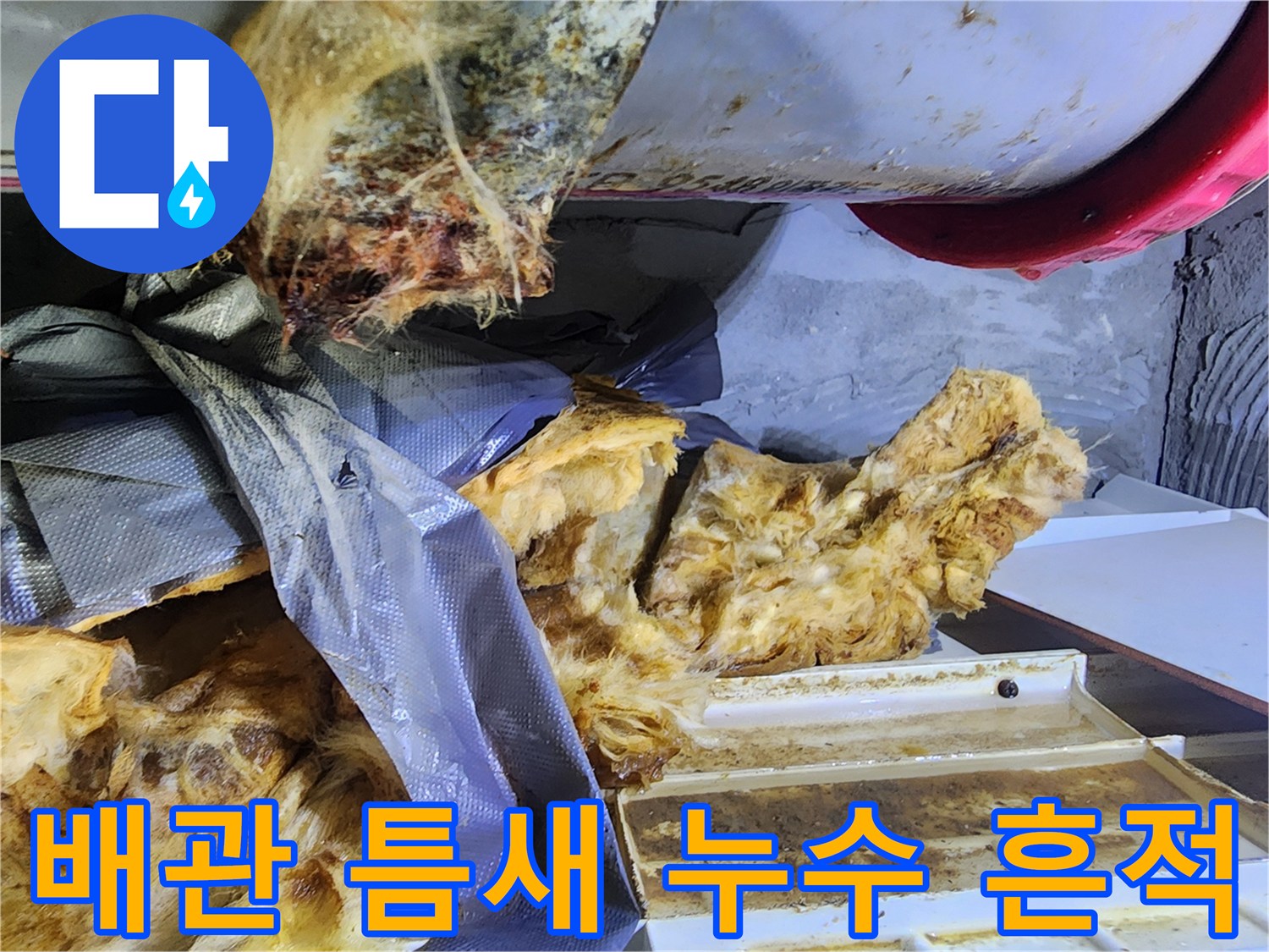 배관 연결 부위 주변의 젖은 보온재와 오염된 잔해물