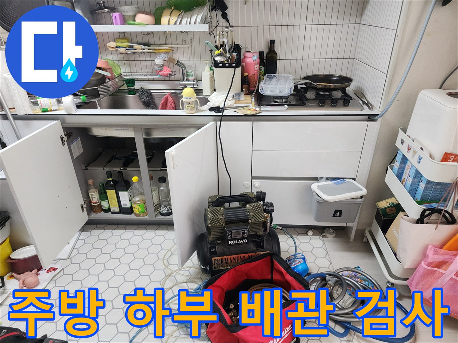 싱크대 하부의 배관 연결 부위와 점검을 위한 장비 배치 상태