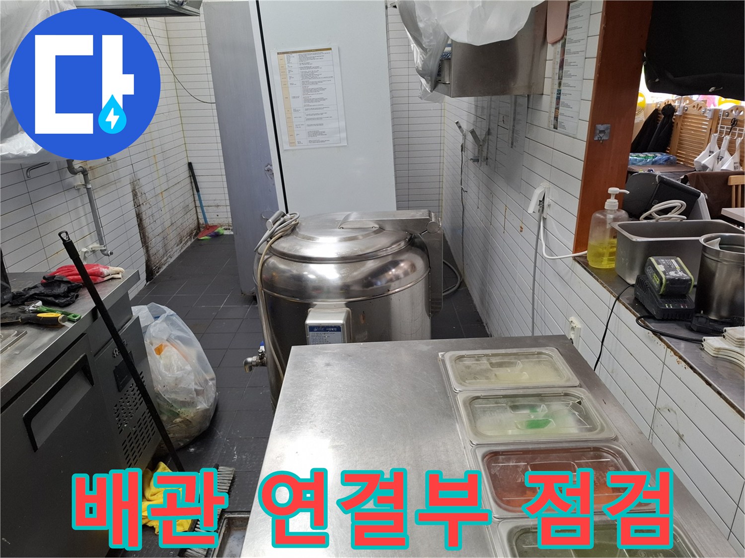 스테인리스 장비 뒤편의 배관 및 타일 벽면 상태 사진
