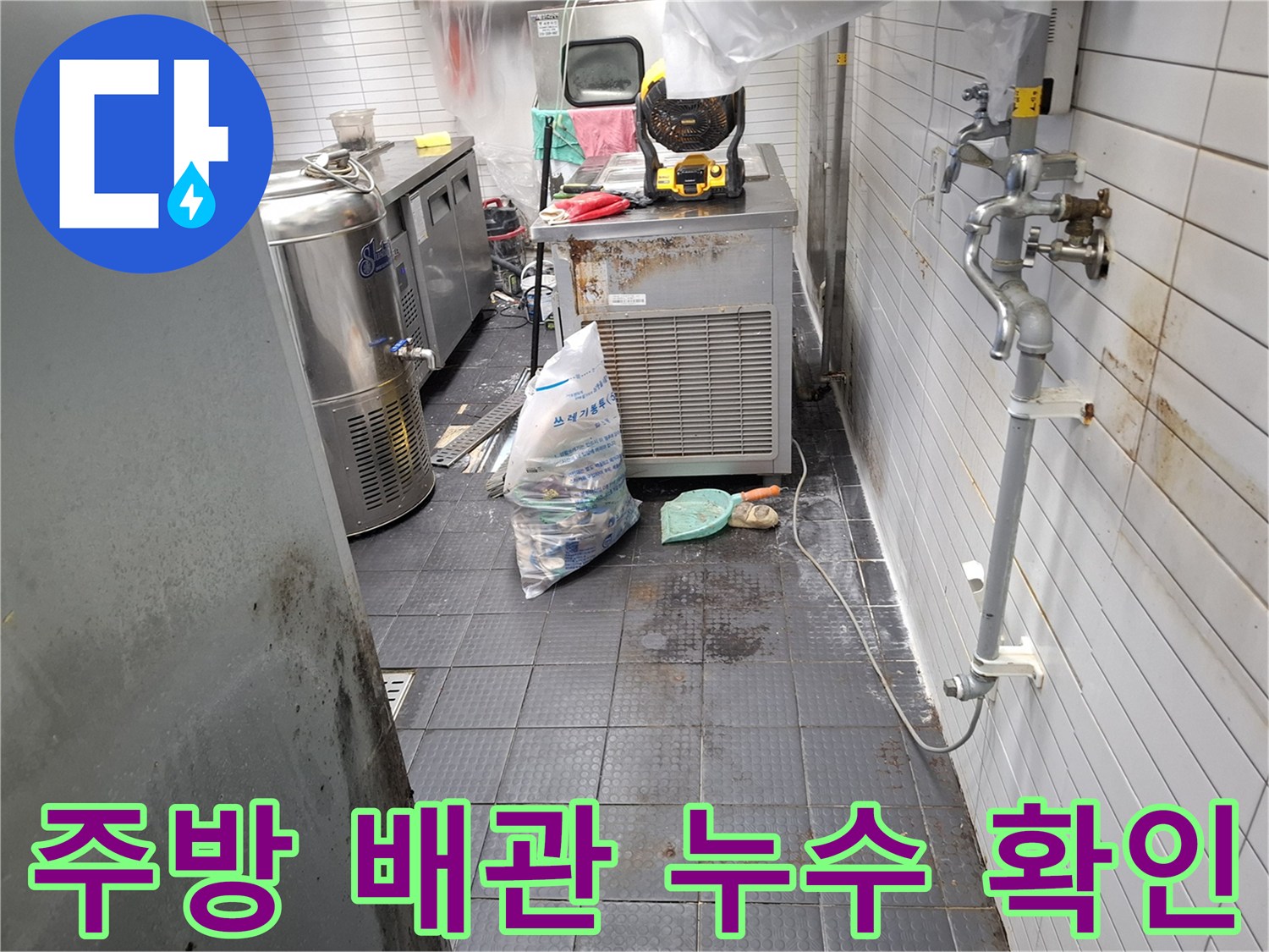 식당 주방 내부-벽면 배관 주변의 물샘 현상과 타일 상태 점검 중