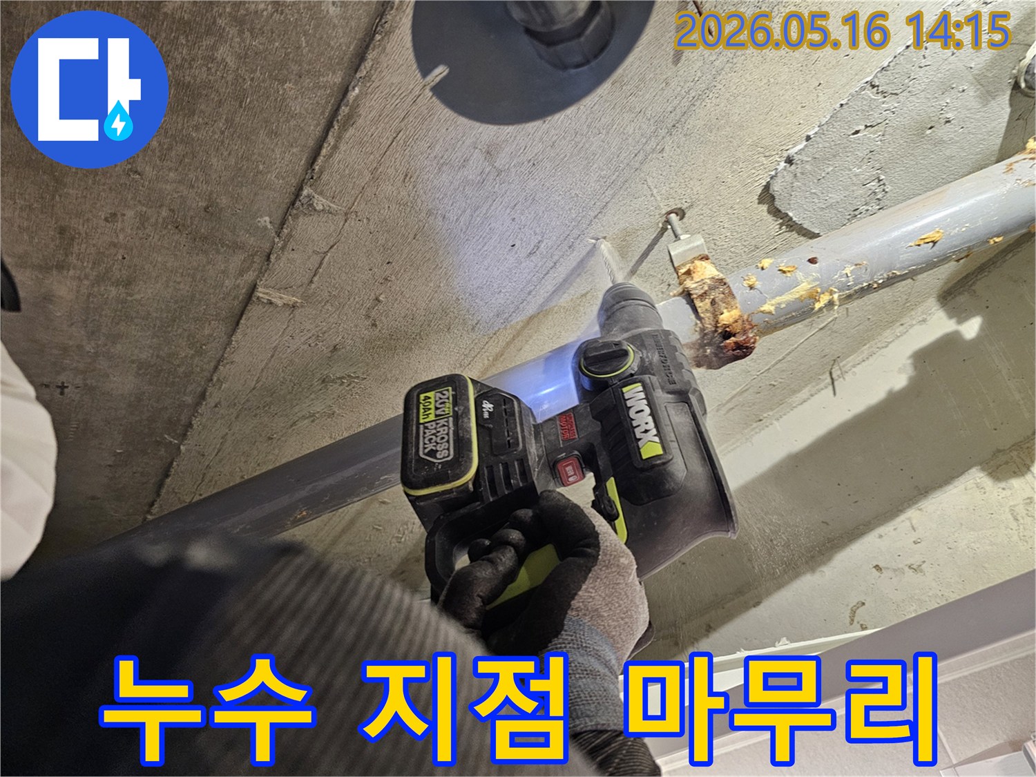 누수 전문가가 천장 배관의 누수 지점을 확인하고 마무리하기 위해 드릴로 콘크리트를 타공하는 모습-정확한 마무리를 위한 필수 단계입니다.