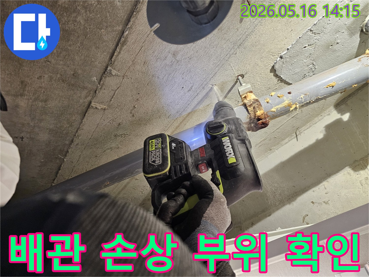 누수 전문가가 천장 배관의 손상 부위를 확인하기 위해 드릴로 콘크리트를 타공하는 모습-정확한 누수 진단을 위한 작업입니다.