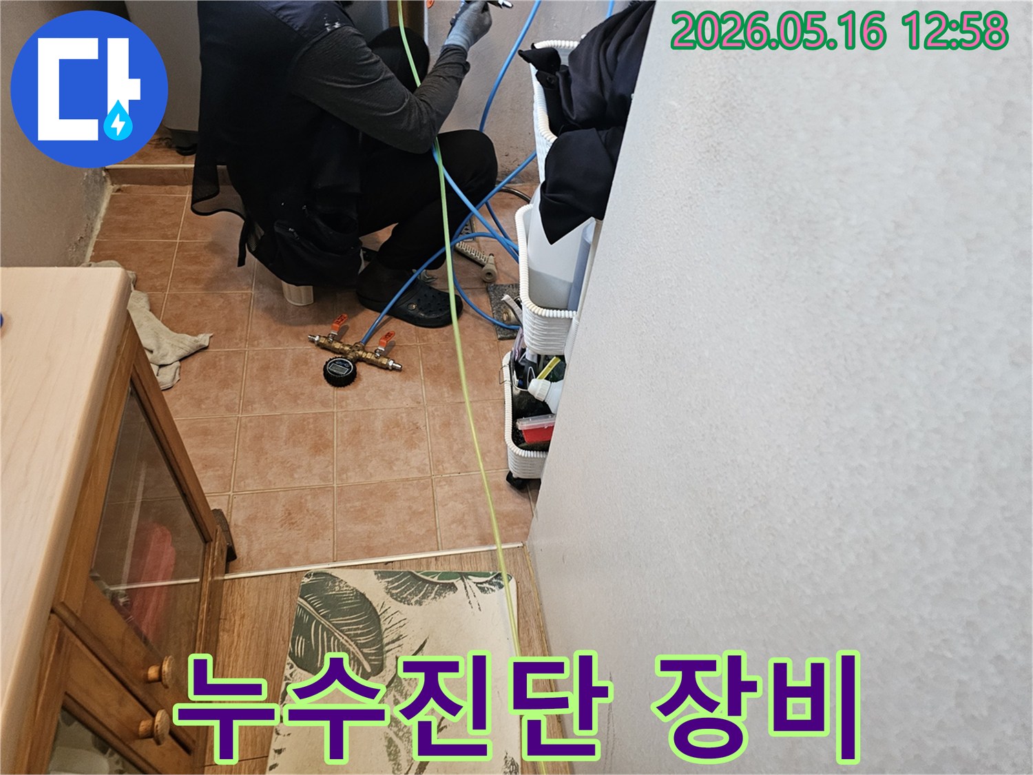 누수-탐지-전문가가-압력-측정-장비를-점검하며-누수-지점을-찾는-작업-사진