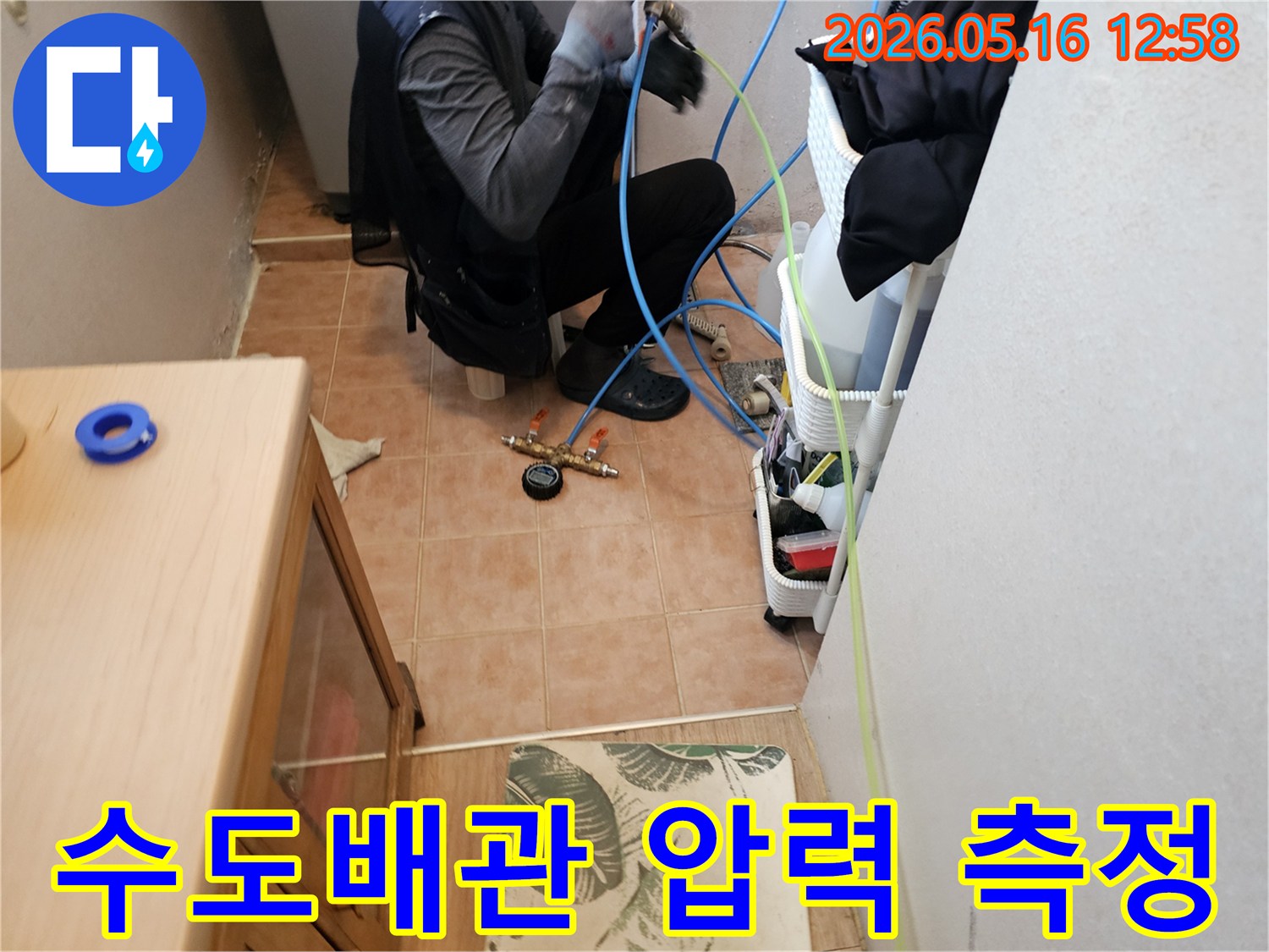 숙련된-기술자가-수도배관-누수-여부를-확인하기-위해-정밀-압력-장비를-연결하고-있는-현장-사진