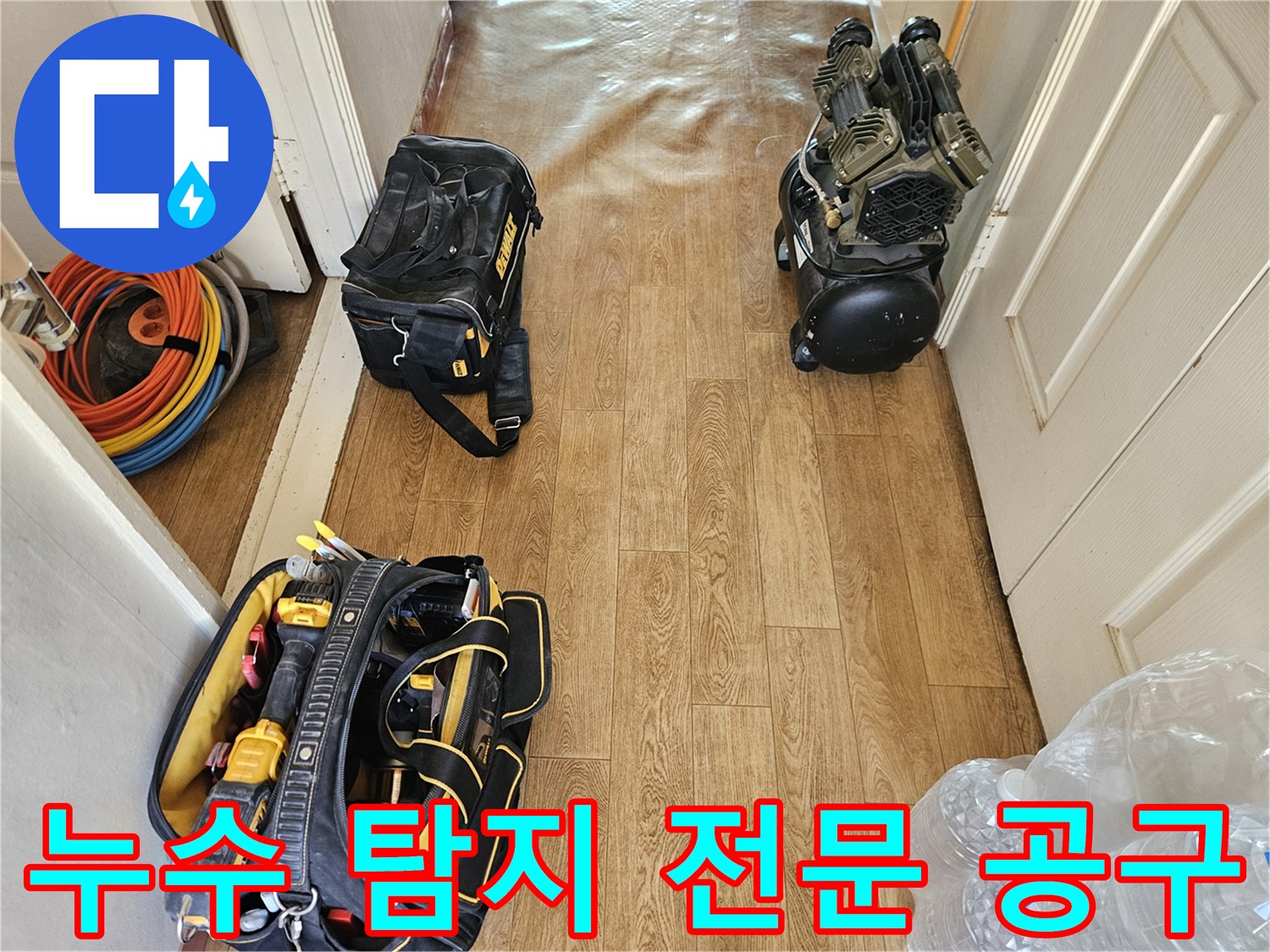 거실 바닥에 배치된 누수 진단용 장비와 작업 도구 세트