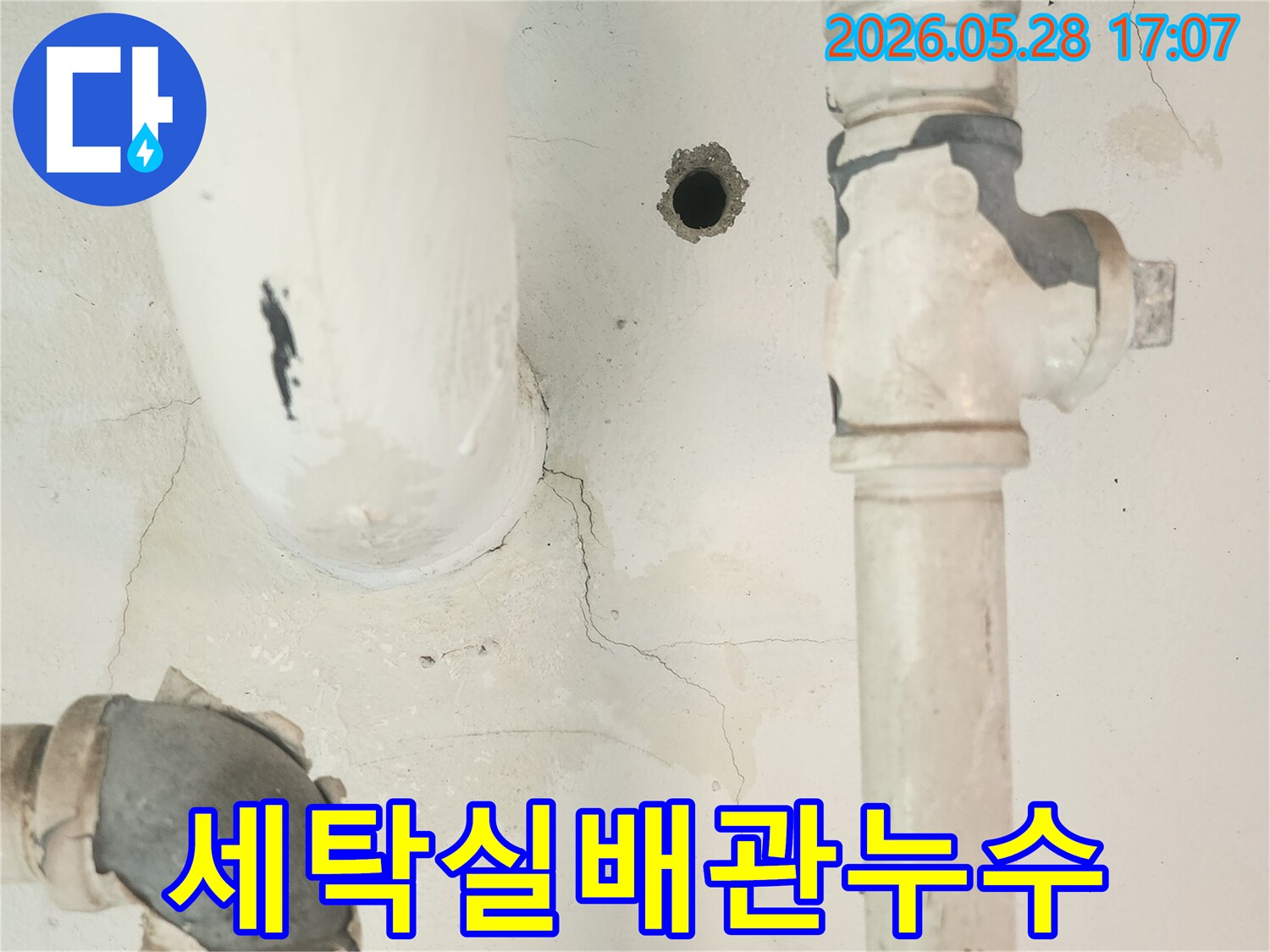 세탁실 공용배관 주변의-벽면 균열과 물 자국을-자세히 관찰하는 모습입니다.