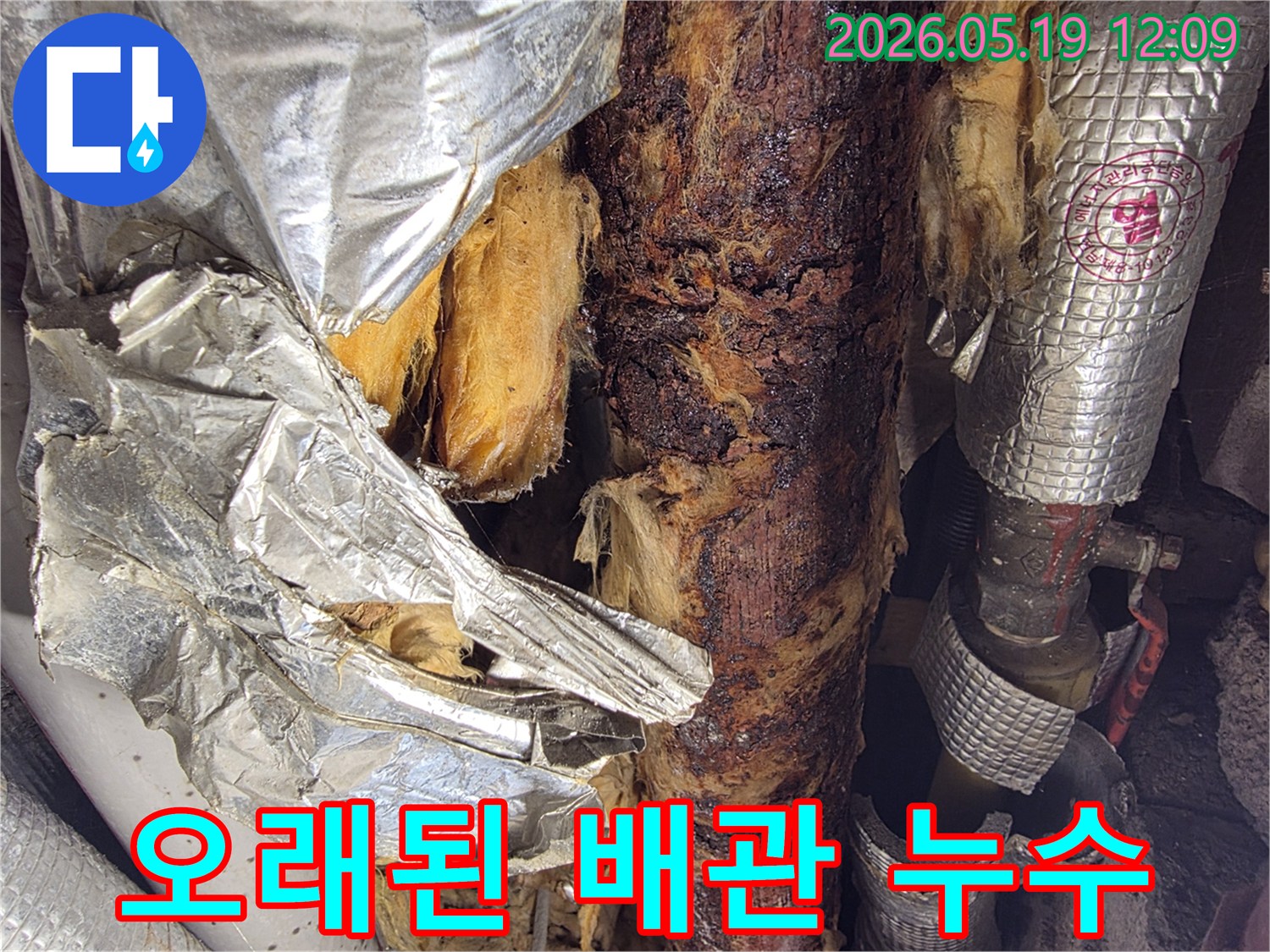 오래된 건물에서-단열재가 손상되고-녹슨 배관이 드러난-누수 현장