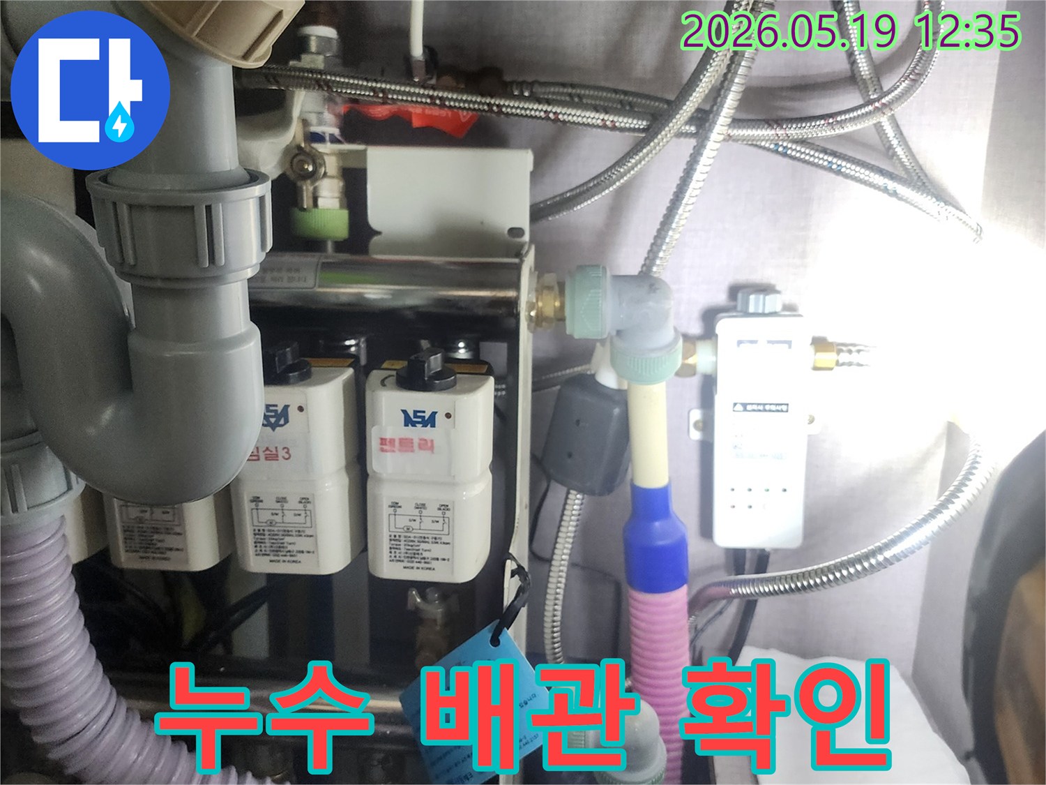 누수 탐지 전문가가-복잡하게 연결된-수도 배관과-정수 장비를-정밀하게-확인하는-과정을-담은 사진입니다.