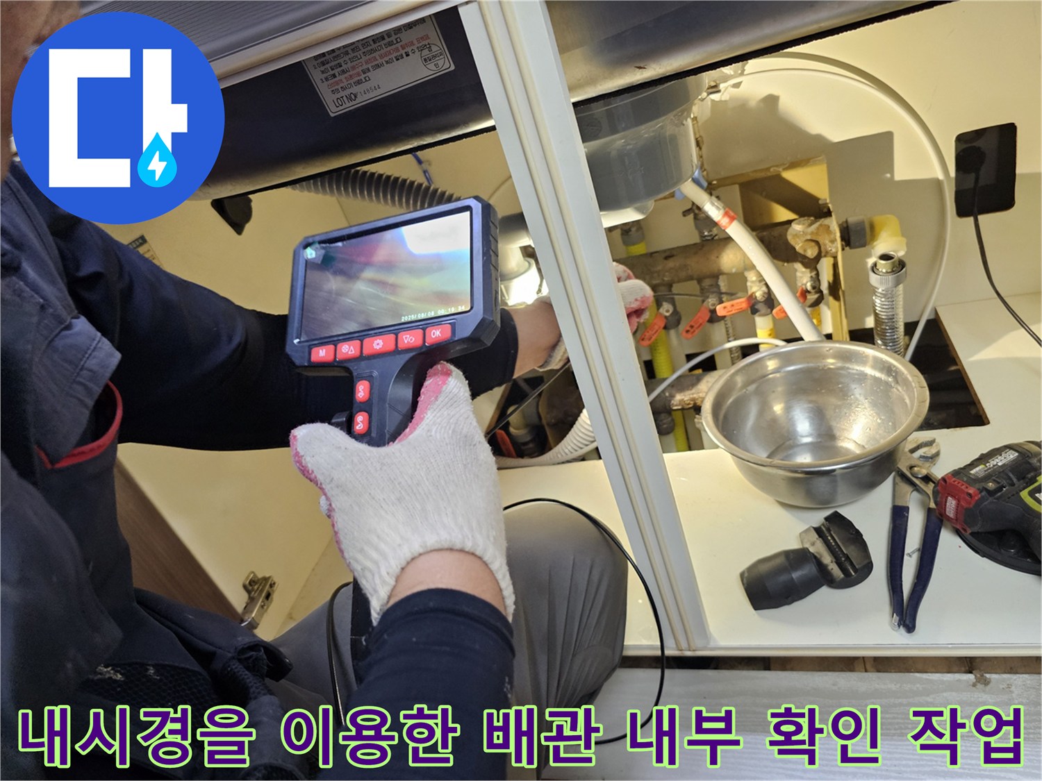 내시경 모니터를 통해 싱크대 하부 배수관의 이상 유무를 정밀하게 점검하고 있습니다.