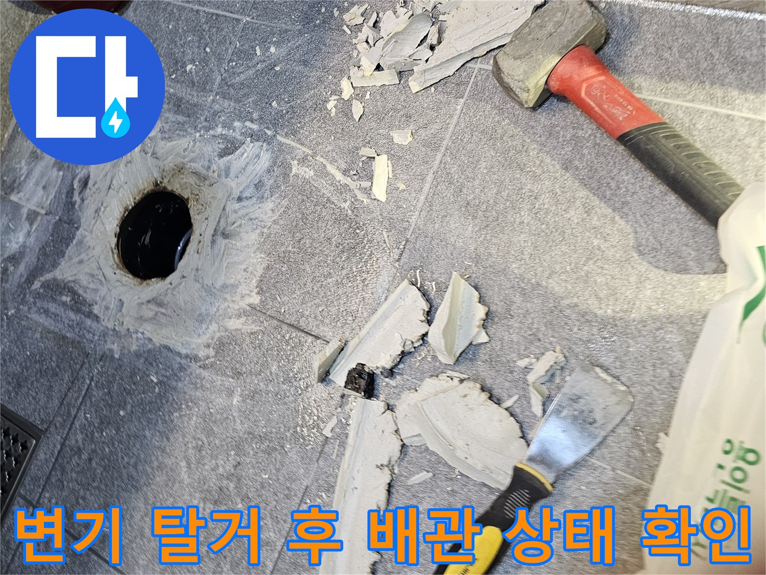 변기를 제거하여 노출된 오수관과 파손된 바닥재 모습입니다.