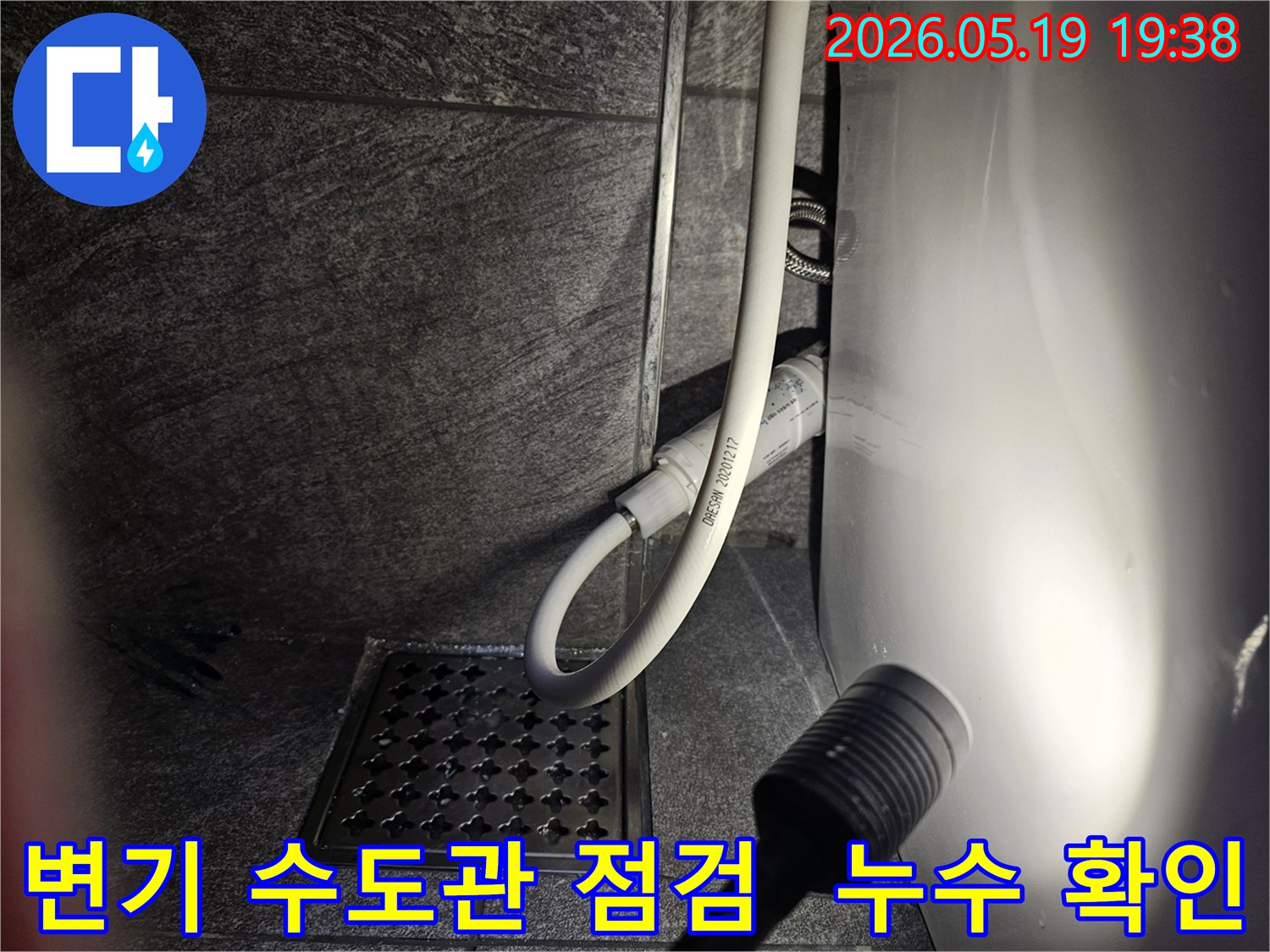 이 이미지는-용인 수지구 풍산아파트 욕실에서-변기 수도관의 누수 여부를-플래시로 비추며-정밀하게 점검하는 현장입니다.