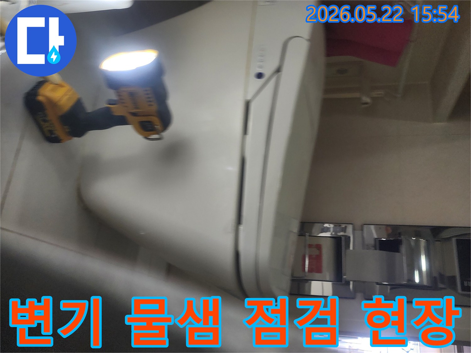 용인 아파트 욕실에서-변기 주변의 물샘 현상을-정확히 파악하기 위해-작업등을 비추며-세밀하게 점검하는-누수 탐지 전문가의 모습