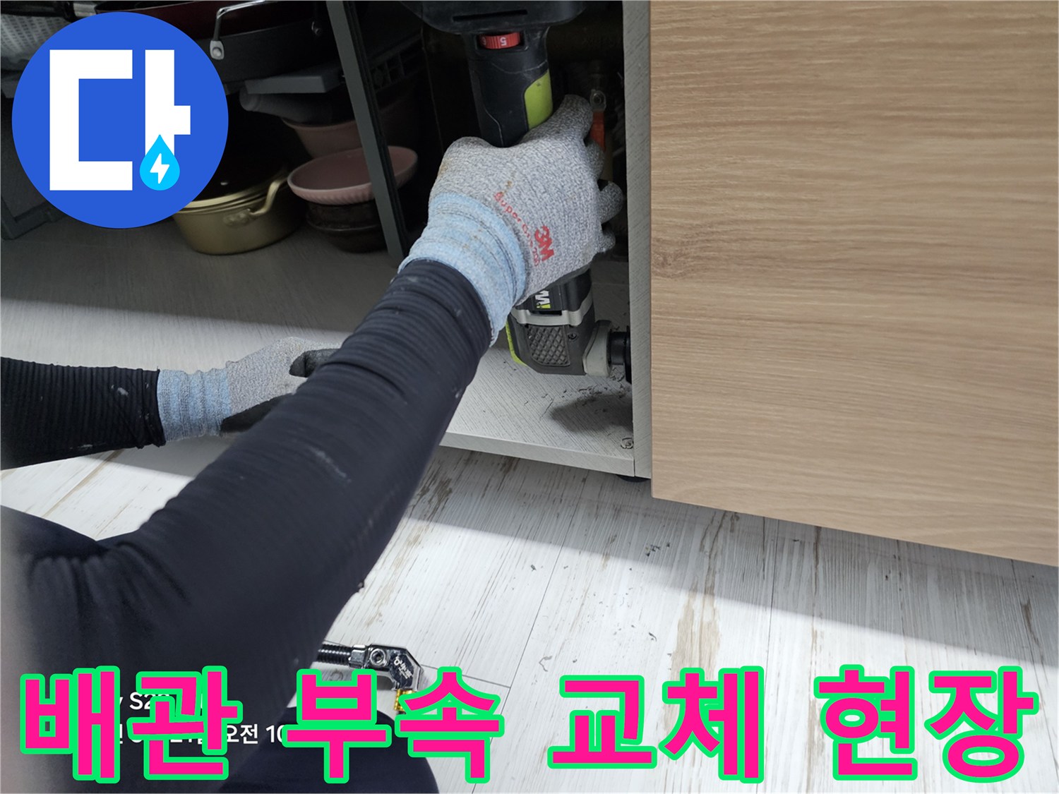 싱크대 하부 내부-전동 공구를 활용한 배관 보수 작업 장면