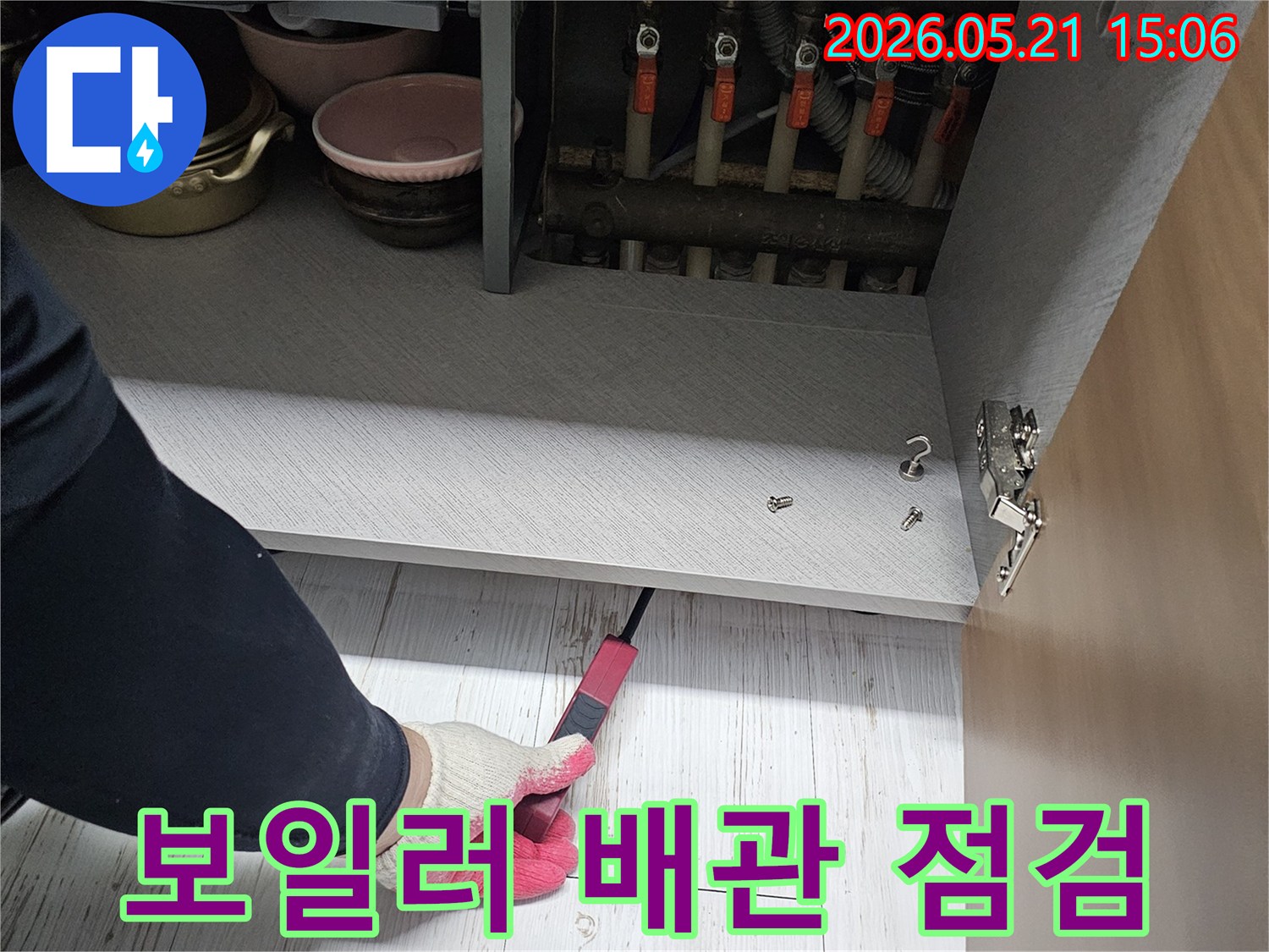 전문 기술자가-보일러 배관의-연결 부위를-세밀하게 확인하며-누수 여부를-판단하고 있습니다