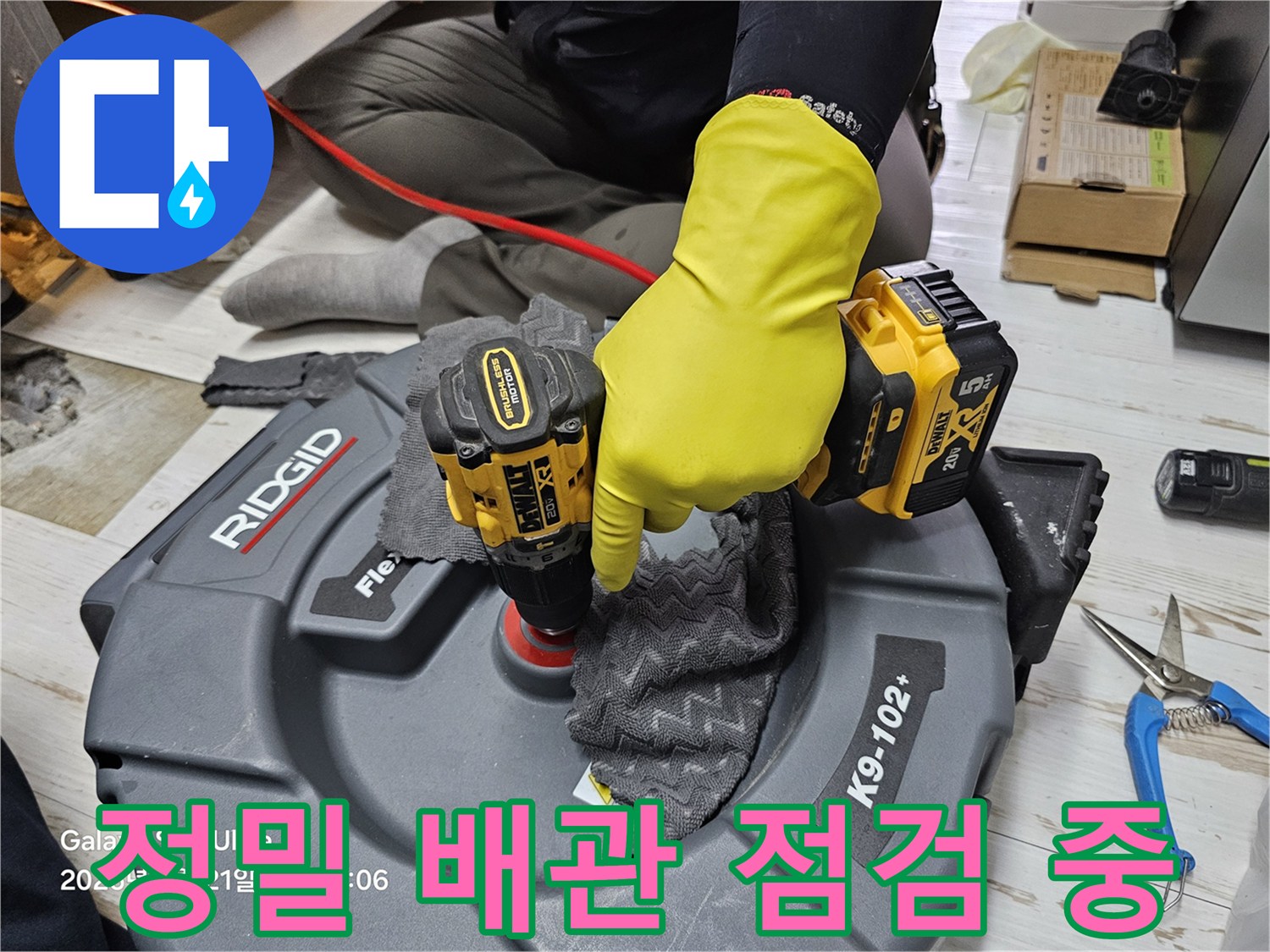 전문 장비를 사용하여 싱크대 하부 배관 연결 부위를 확인하는 모습
