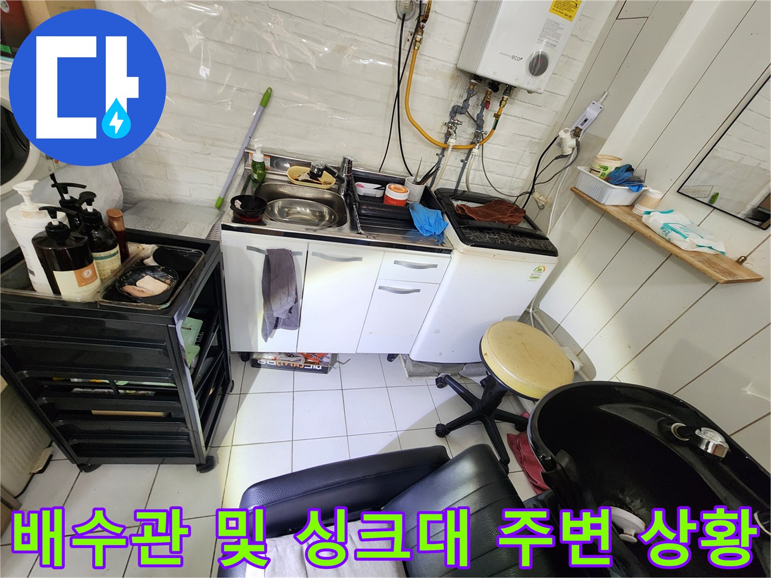 싱크대 하부와 세탁기 배수 호스가 모여 있는 상가 현장 모습