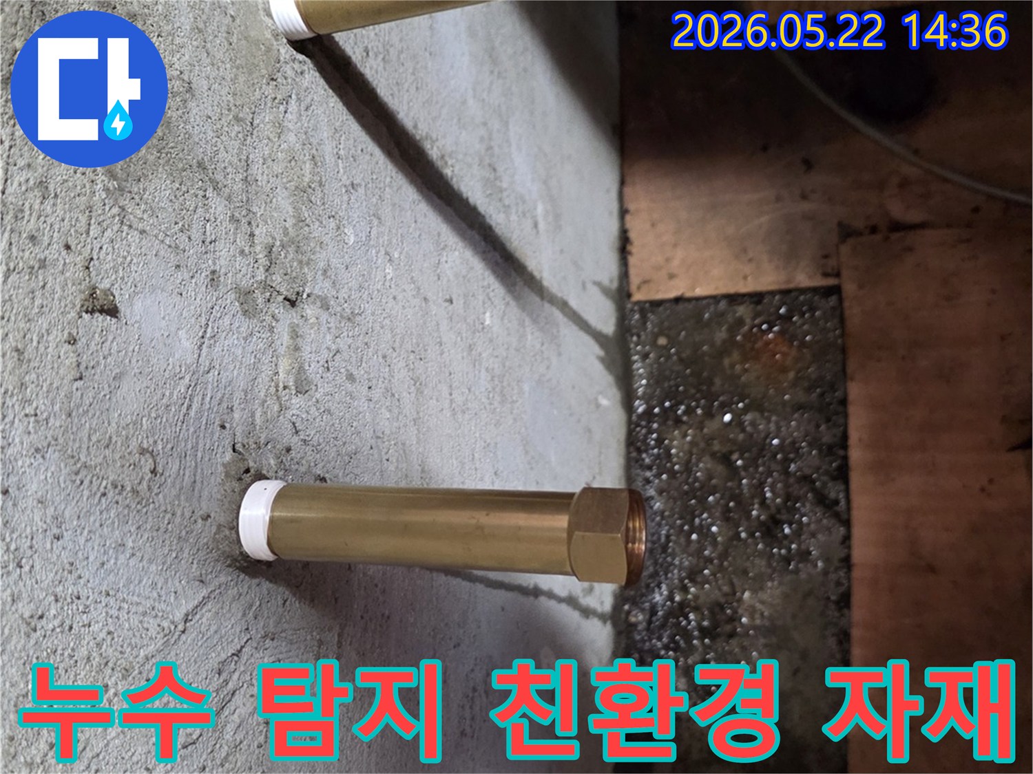 천장에서 내려온 금속 배관 아래로 물이 고여있는-누수 현장을 탐지한 후 친환경 보수 자재를 사용하는 모습입니다.