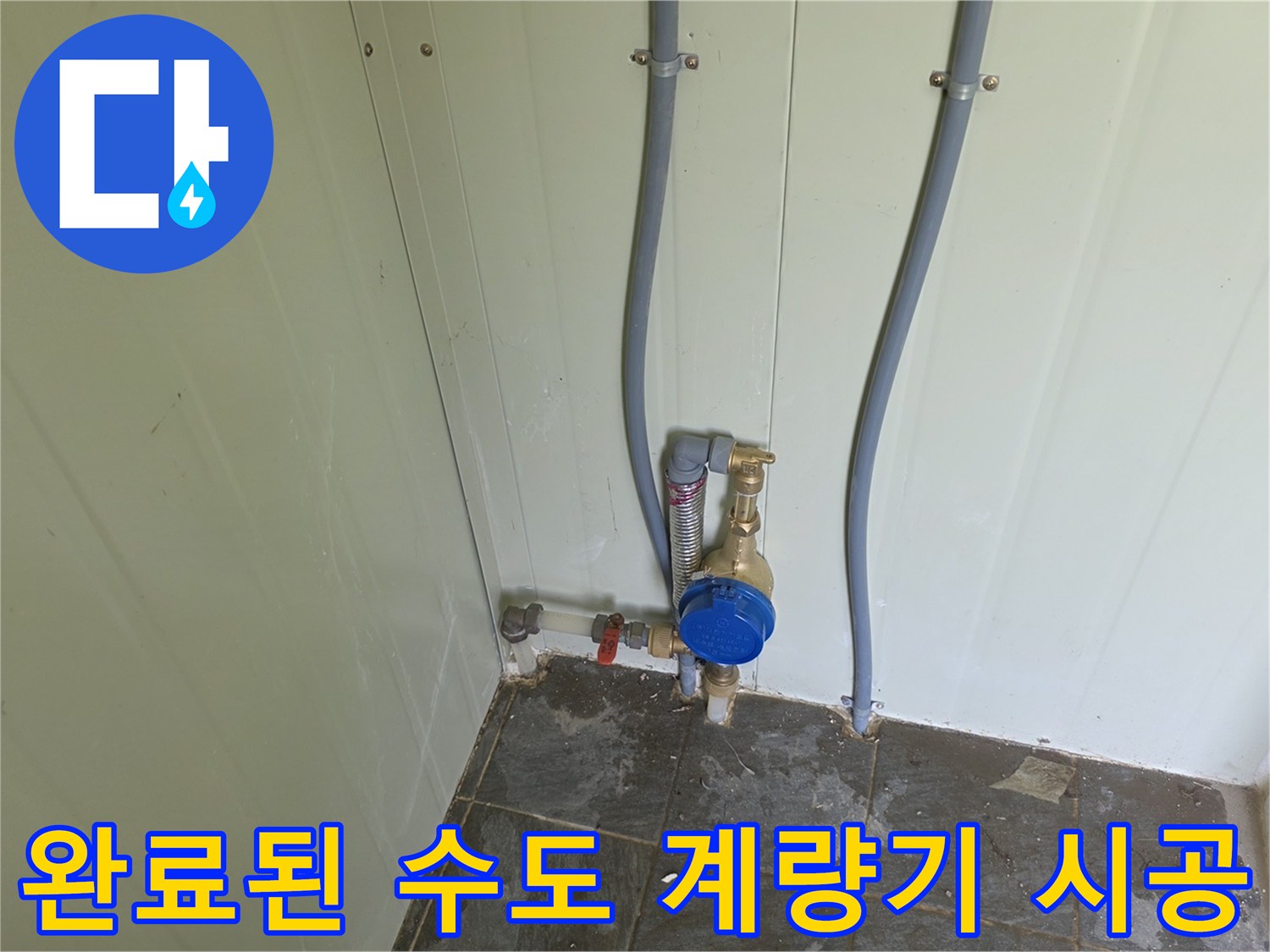 벽면 배관에 연결되어 설치 완료된 파란색 수도 계량기