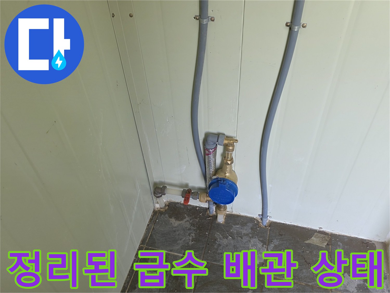 벽면에 고정된 수직 배관과 설치 완료된 계량기