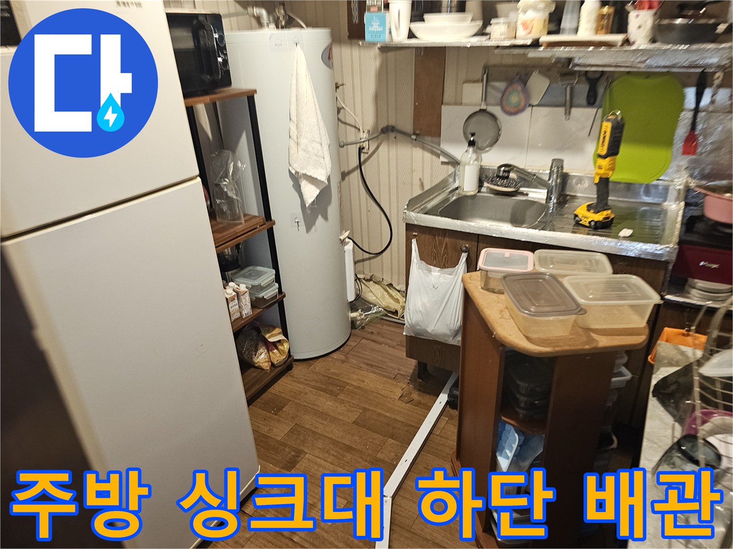 싱크대 옆 온수기 및 연결된 급수 배선 점검 이미지