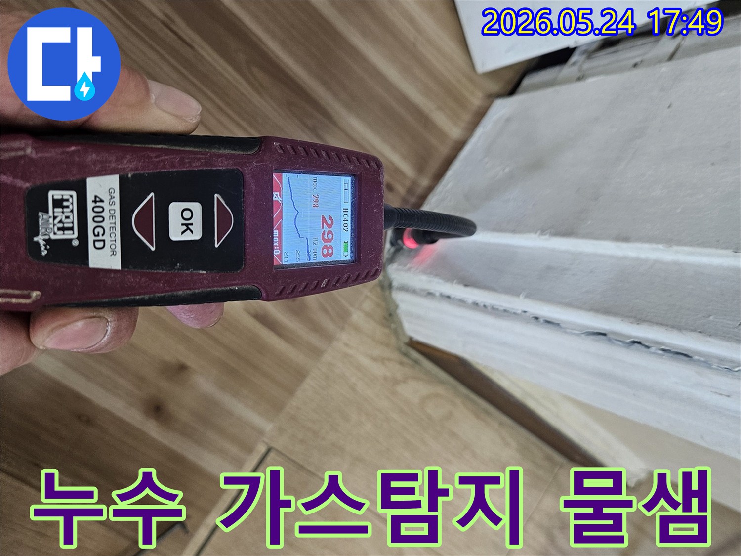 누수 엔지니어가 가스 탐지기를 사용하여 벽면과 바닥 경계에서 누수 반응을 정밀하게 확인하고 있습니다.
