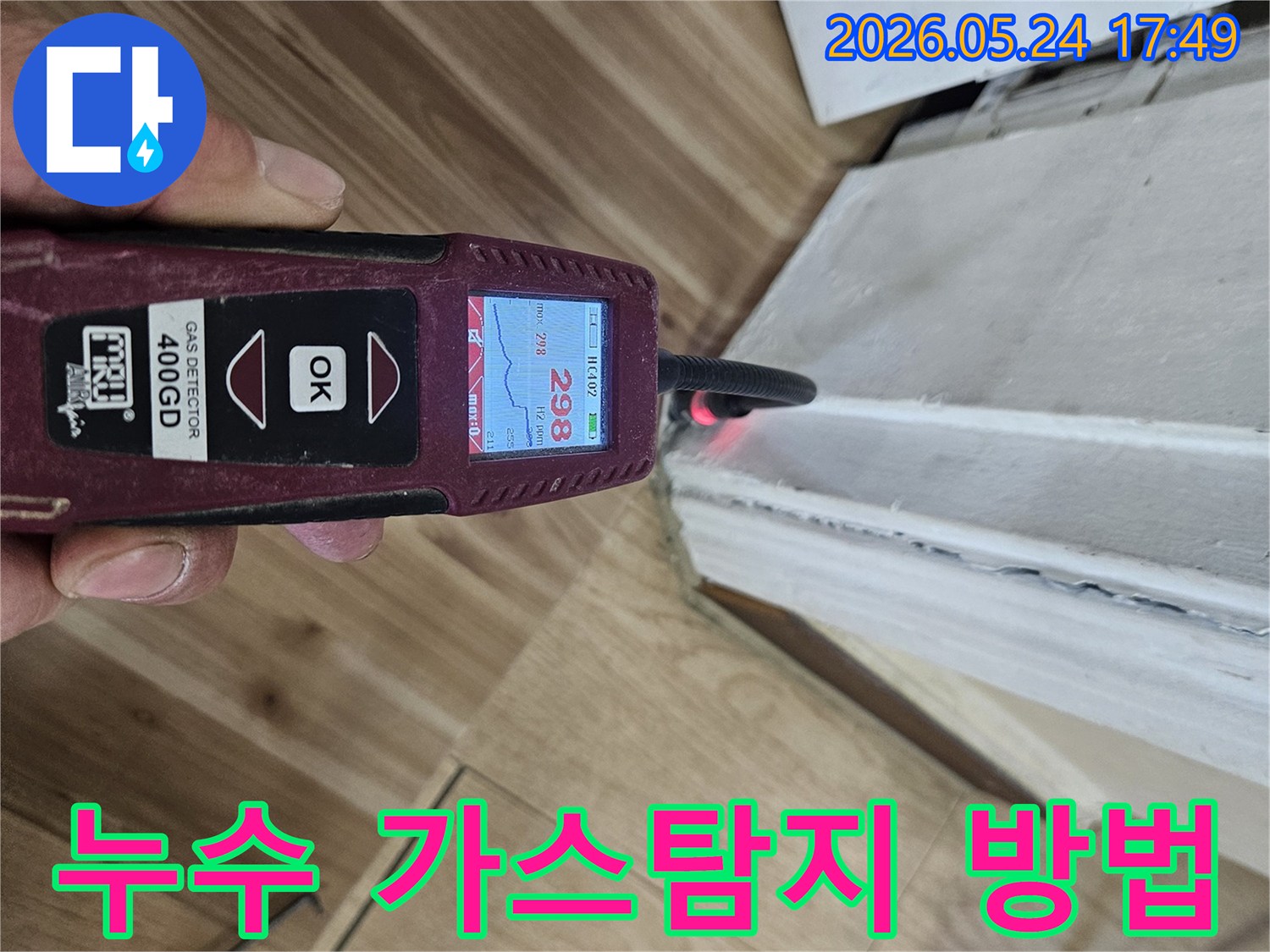 누수 엔지니어가 가스 탐지기를 사용하여 벽면과 바닥 경계에서 누수 반응을 정밀하게 확인하고 있습니다.