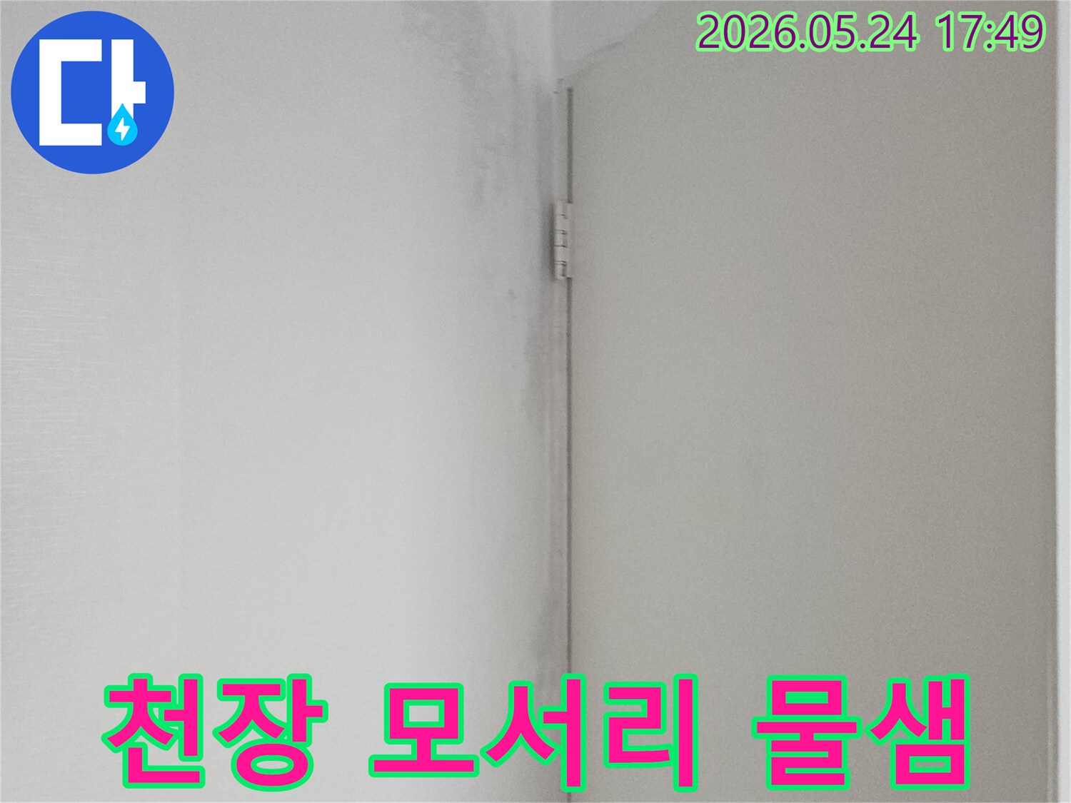 천장과 벽의 접합부에서 물이 새어 벽지가 축축하게 젖어 있는 모습-누수 발생을 알리는 명확한 증거입니다.
