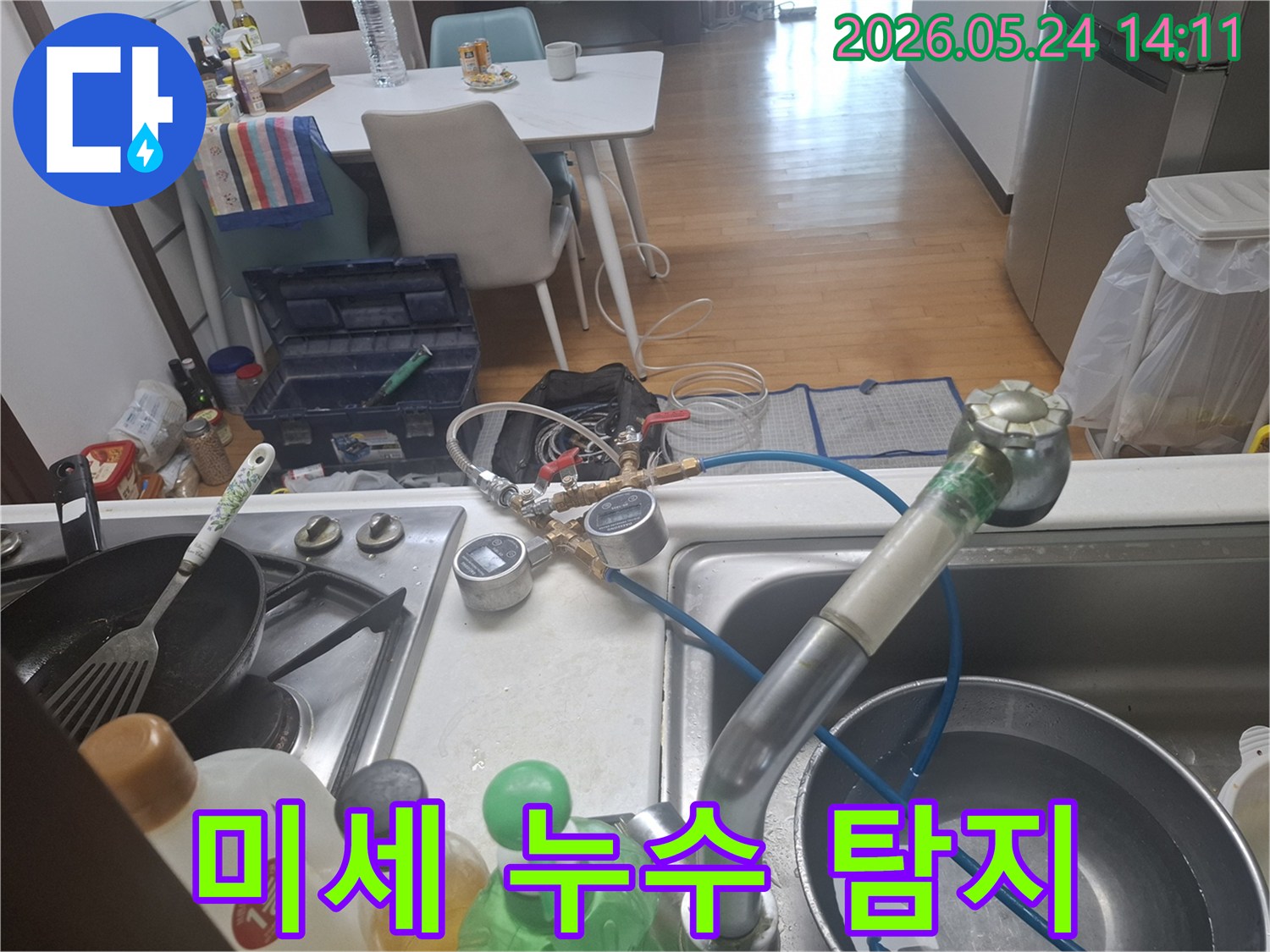 정확한 누수 지점을 파악하기 위해-싱크대 수도에-압력 측정 장치를-설치하고-점검하는-모습입니다