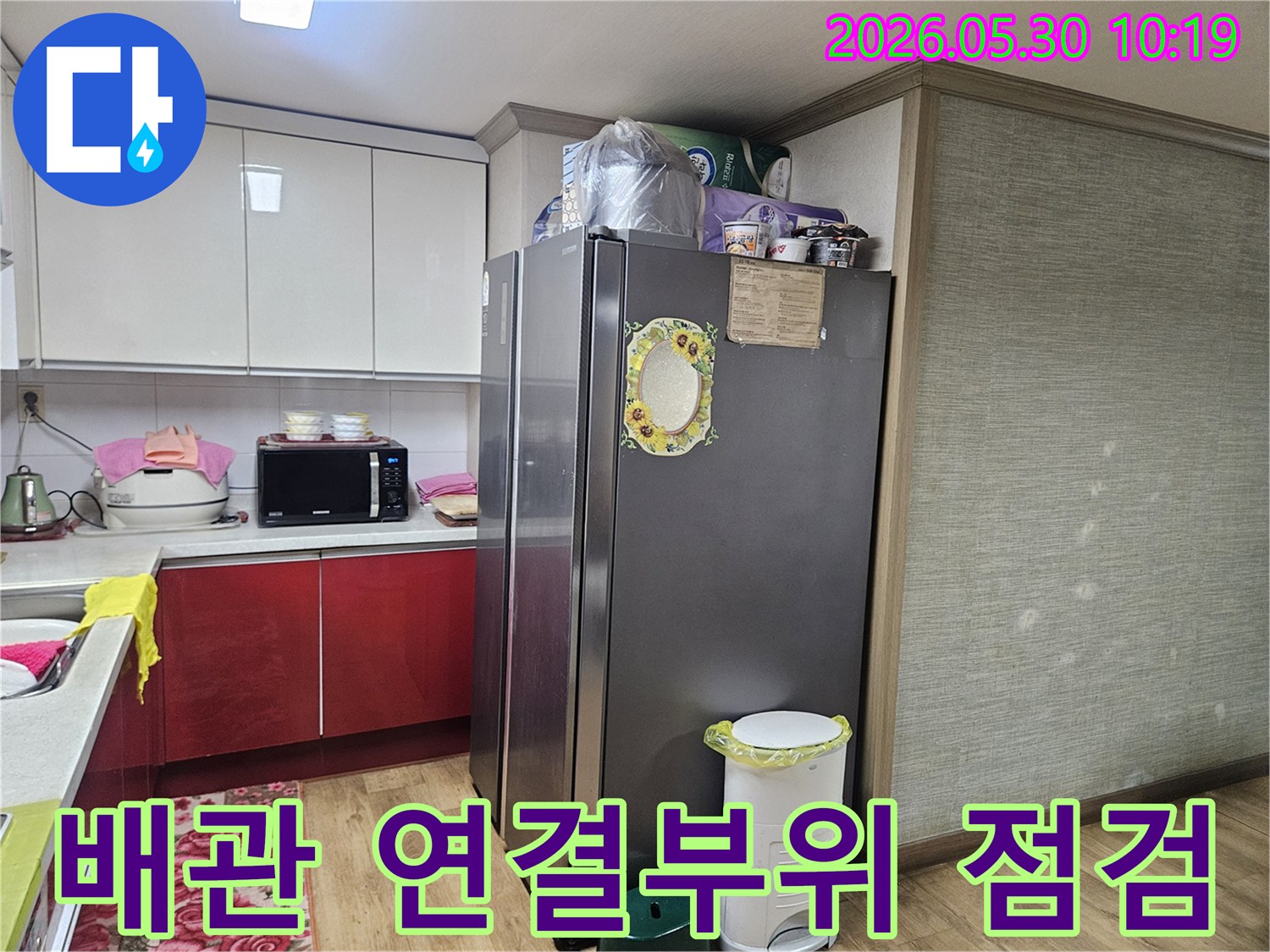 누수 엔지니어가-강동구 천호동 아파트 주방에서-배관 연결부위의 누수 여부를-육안으로 꼼꼼히 확인하고 있습니다