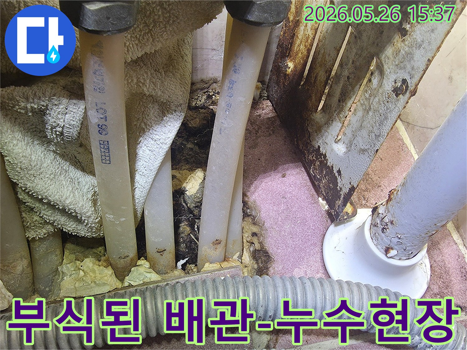 이 사진은 부식된 배관과 주변의 젖은 단열재-물때를 보여주며 누수 문제를 시사합니다.