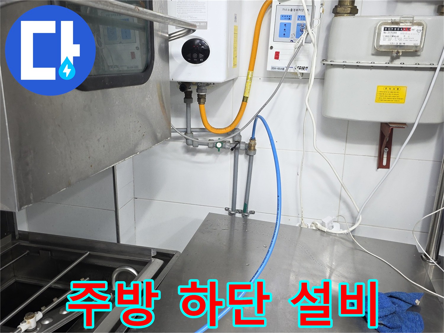 스테인리스 조리대 아래 설치된 가스 및 급수 배관의 연결 상태