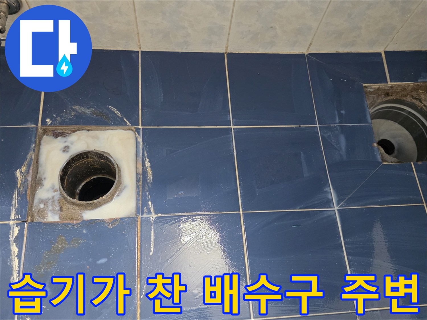 배수구 유가 근처 타일이 젖어 있고 하얀 자국이 남은 사진입니다.