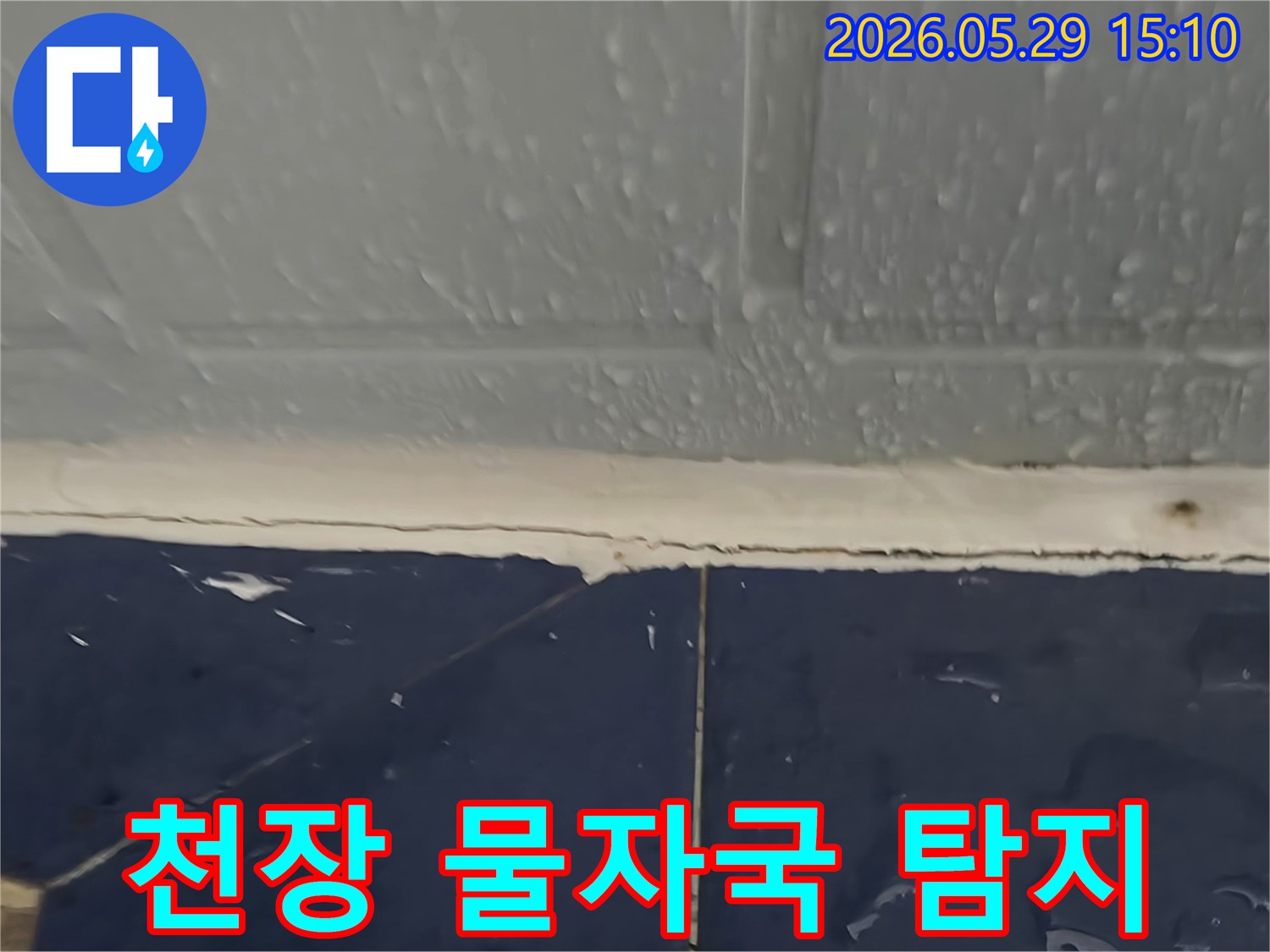 천장과 벽면 경계-오래된 물자국과 함께 물방울이 맺힌 모습-누수 전문가가 숨은 원인을 탐지 중
