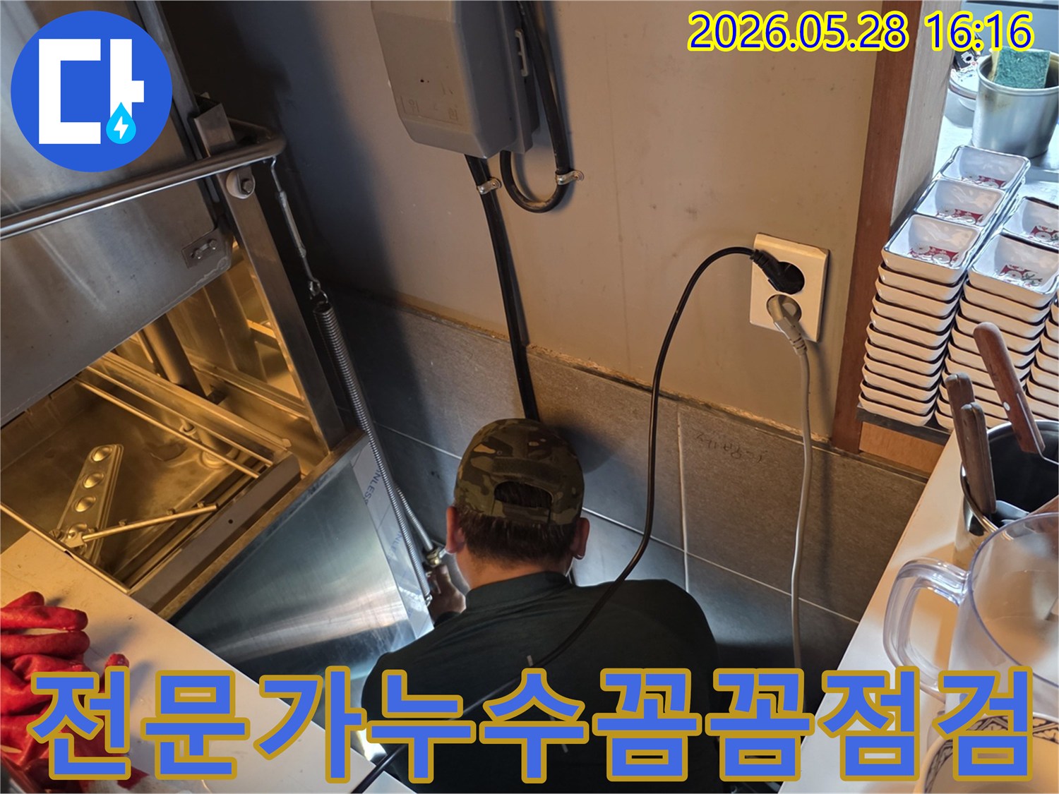 숙련된 누수 전문가가-주방 후드 아래-좁은 공간에서-배관의 모든 부분을-꼼꼼하게 점검하는 모습
