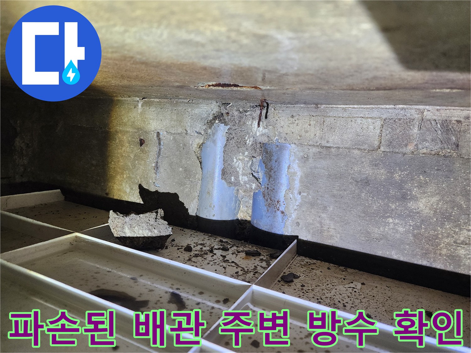 노출된 하수도 배관과 손상된 콘크리트 부위를 정밀 점검하는 장면