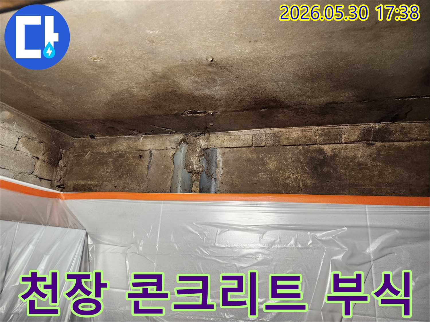 천장과 벽이 만나는 부분에서-누수로 인해 콘크리트가 부식되고-손상된 현장을 보여주는 사진