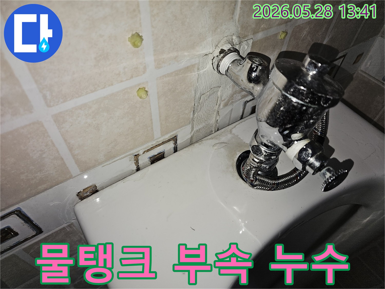 이 이미지는 변기 뒤쪽 물탱크 부속품에서 발생한 누수를 보여줍니다-이는 부속품의 노후화나 설치 불량으로 인해 발생할 수 있으며-신속한 교체 및 실리콘 마감이 필요합니다.