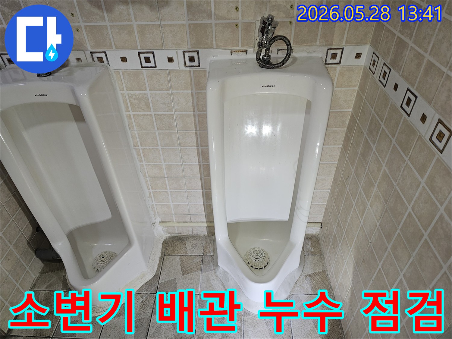 화장실 소변기 하수 배관에서-누수가 발생하여-전문가가 육안으로 확인하고 있는 장면입니다.