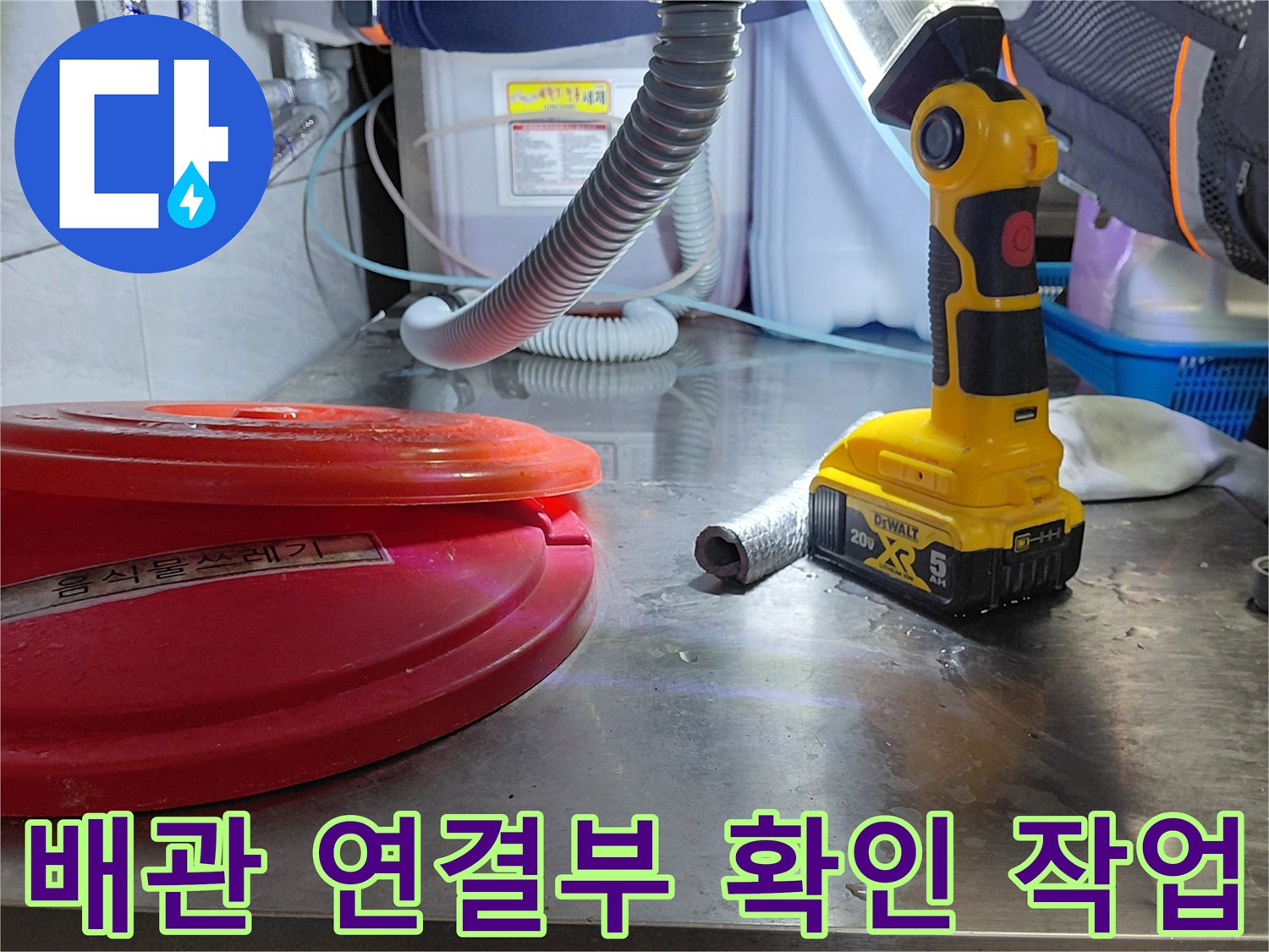 조명 아래 보이는 에이콘 배관과 수리용 전동 공구