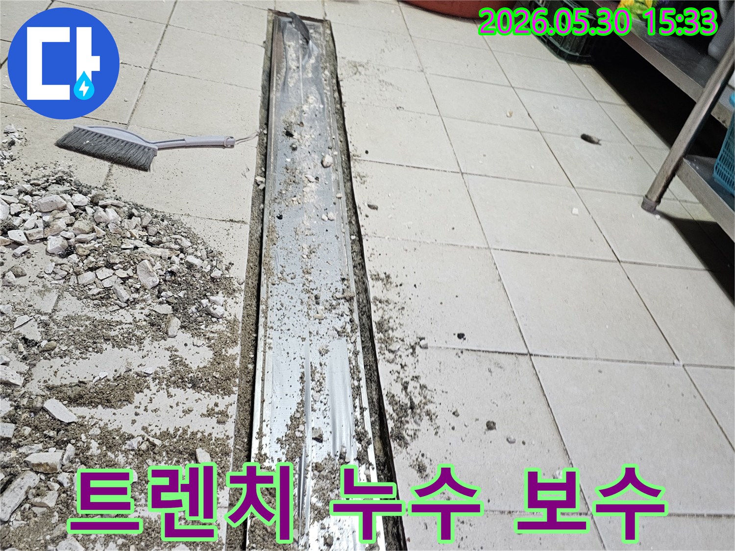 이 사진은-상가 바닥 트렌치에서-발생한 누수를-보수하기 위해-주변 타일과-배관을 해체하는-작업 과정을-보여줍니다.