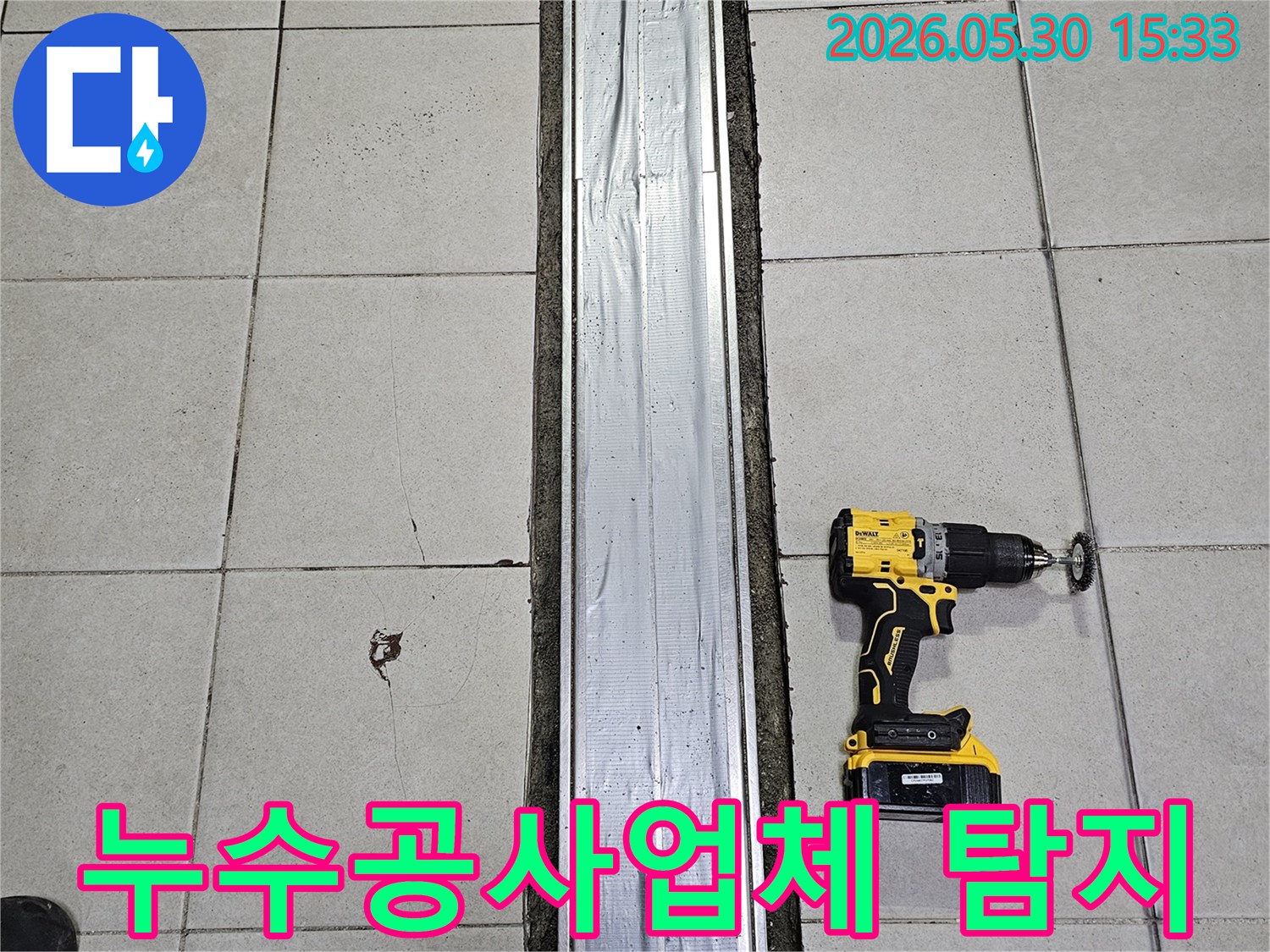 전문 누수공사업체가-정밀 탐지 기술을 활용하여-타일 바닥에서-드릴 작업을 준비하는 모습입니다.
