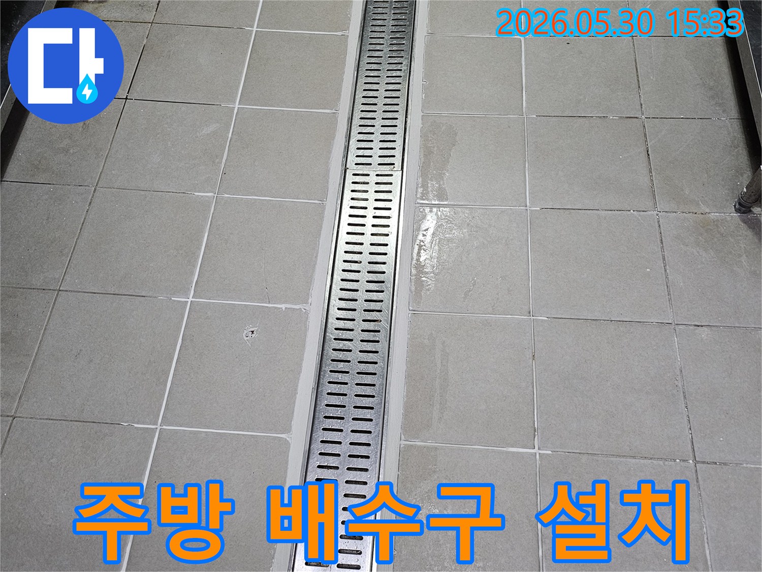 주방 타일 벽면에-새롭게 설치된-스테인리스 선형 배수구-물이 고이지 않고-빠르게 배수되도록-시공된 모습