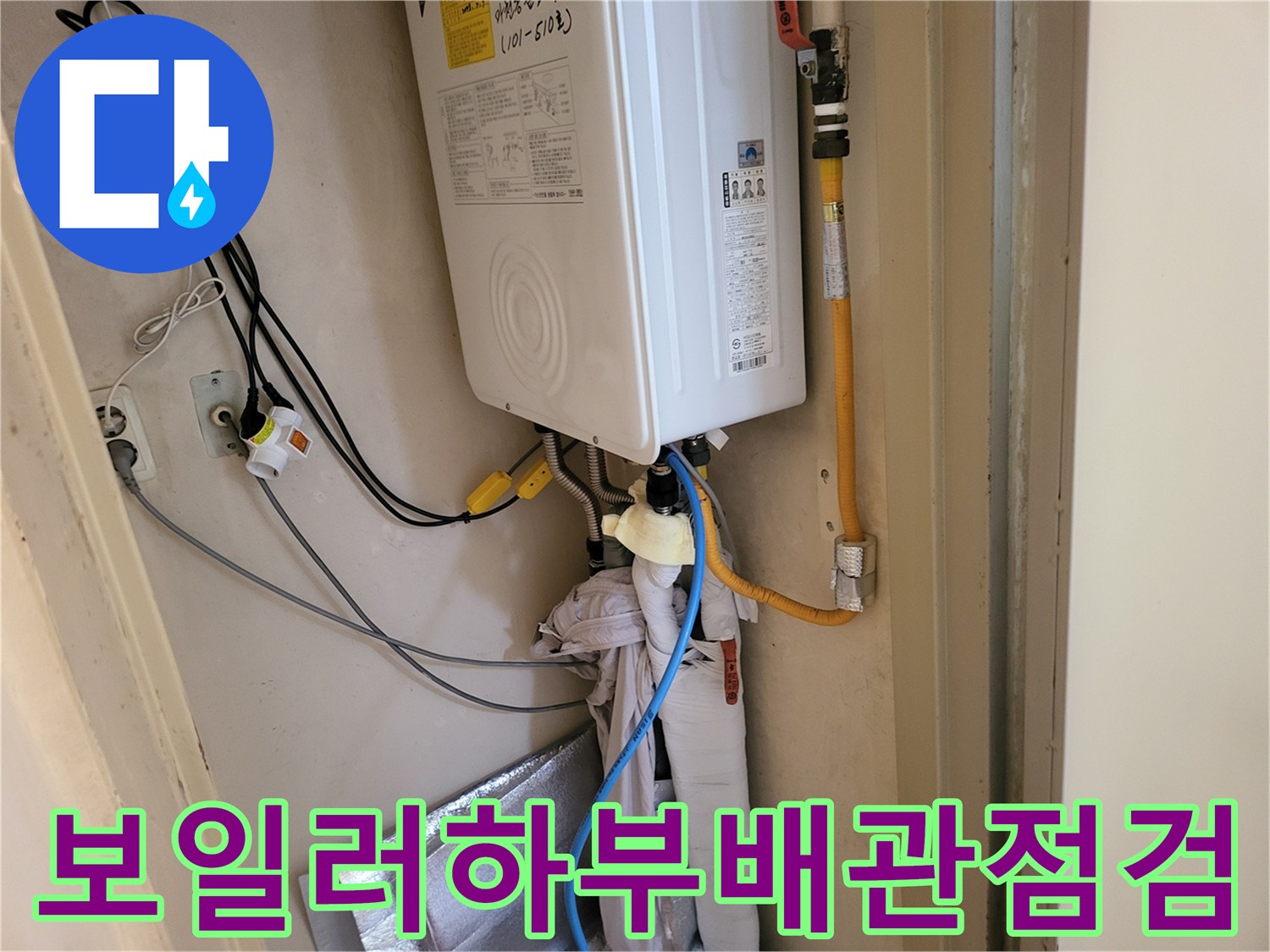 보일러 하단에 설치된 노란색 가스 배관과 하부 급수 연결 부위입니다.