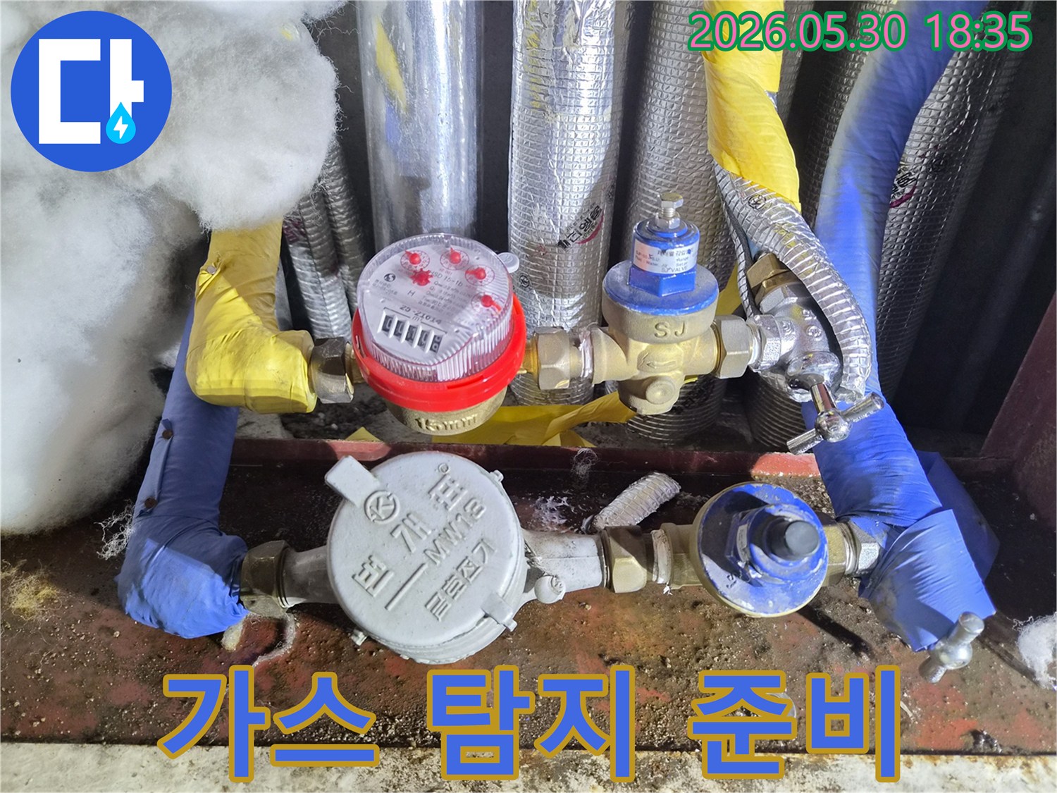 이 이미지는 수도 계량기 주변의-배관에 가스 탐지 장비를-연결하여-미세한 누수 지점을-정확하게 찾아내기 위한-준비 과정을-보여줍니다