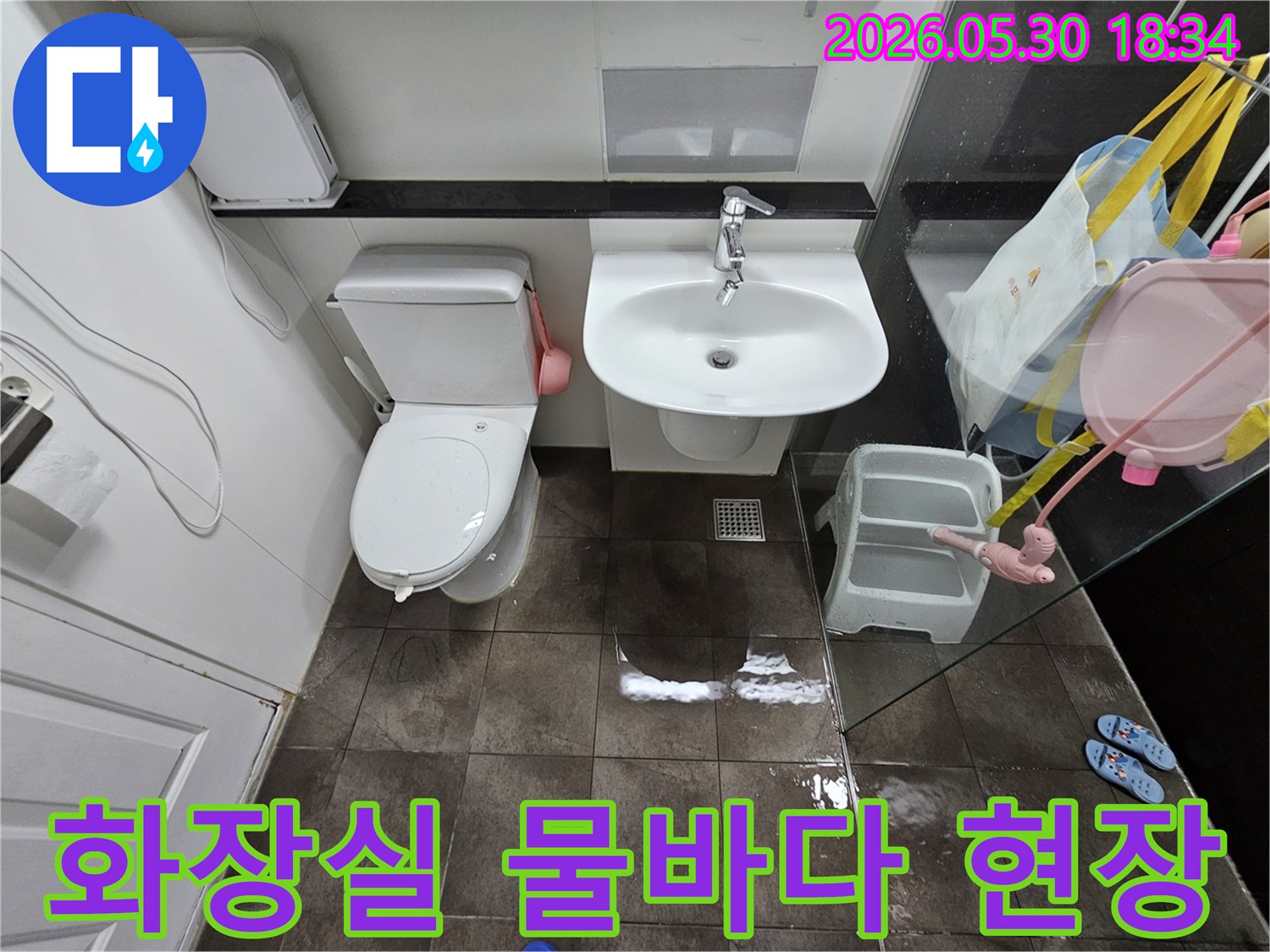 타일-바닥에-고인-물과-젖은-표면은-화장실-내부에서-발생한-누수-문제를-시각적으로-증명합니다