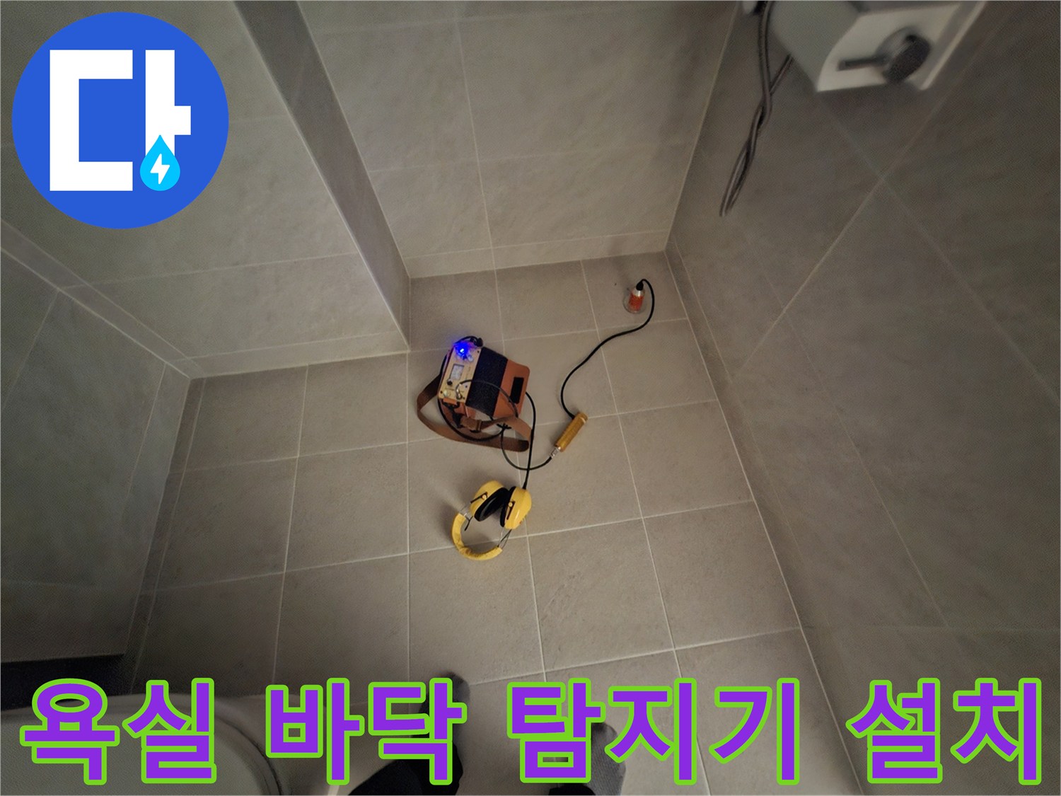 타일 바닥 위에 배치된 노란색 가스 탐지기와 연결 케이블