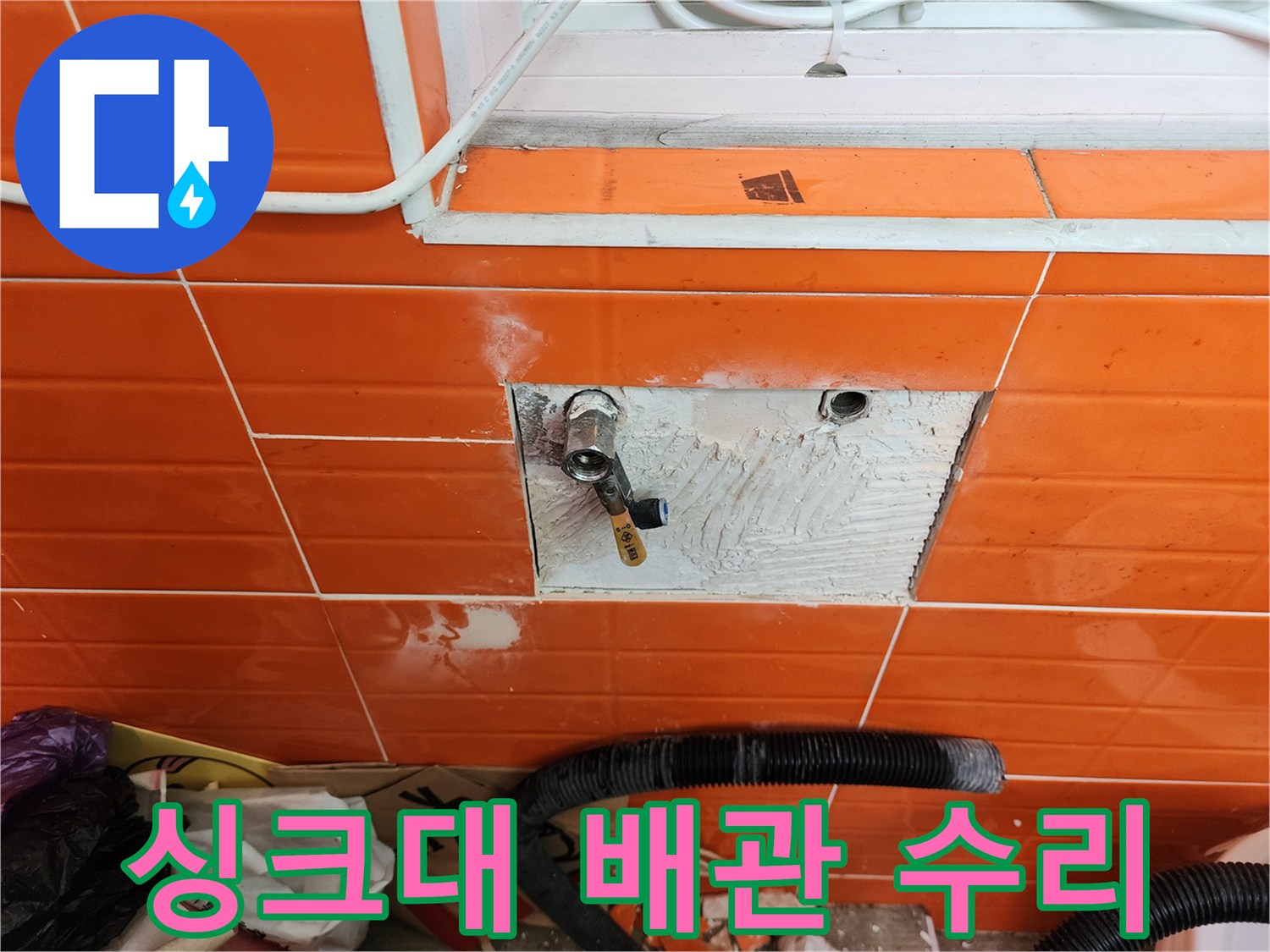 싱크대 아래 벽면의-타일을 제거하고-누수된 수도 배관을-수리하는 작업 현장