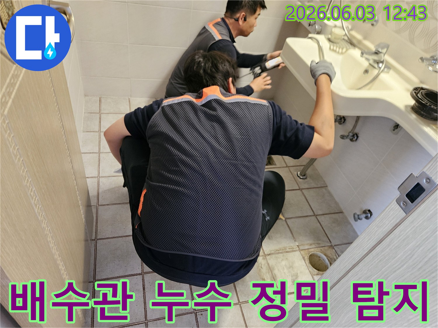 서울 중랑구 아파트 화장실에서-두 명의 누수 전문가가-배수관 누수 지점을-정밀하게 탐지하는 모습