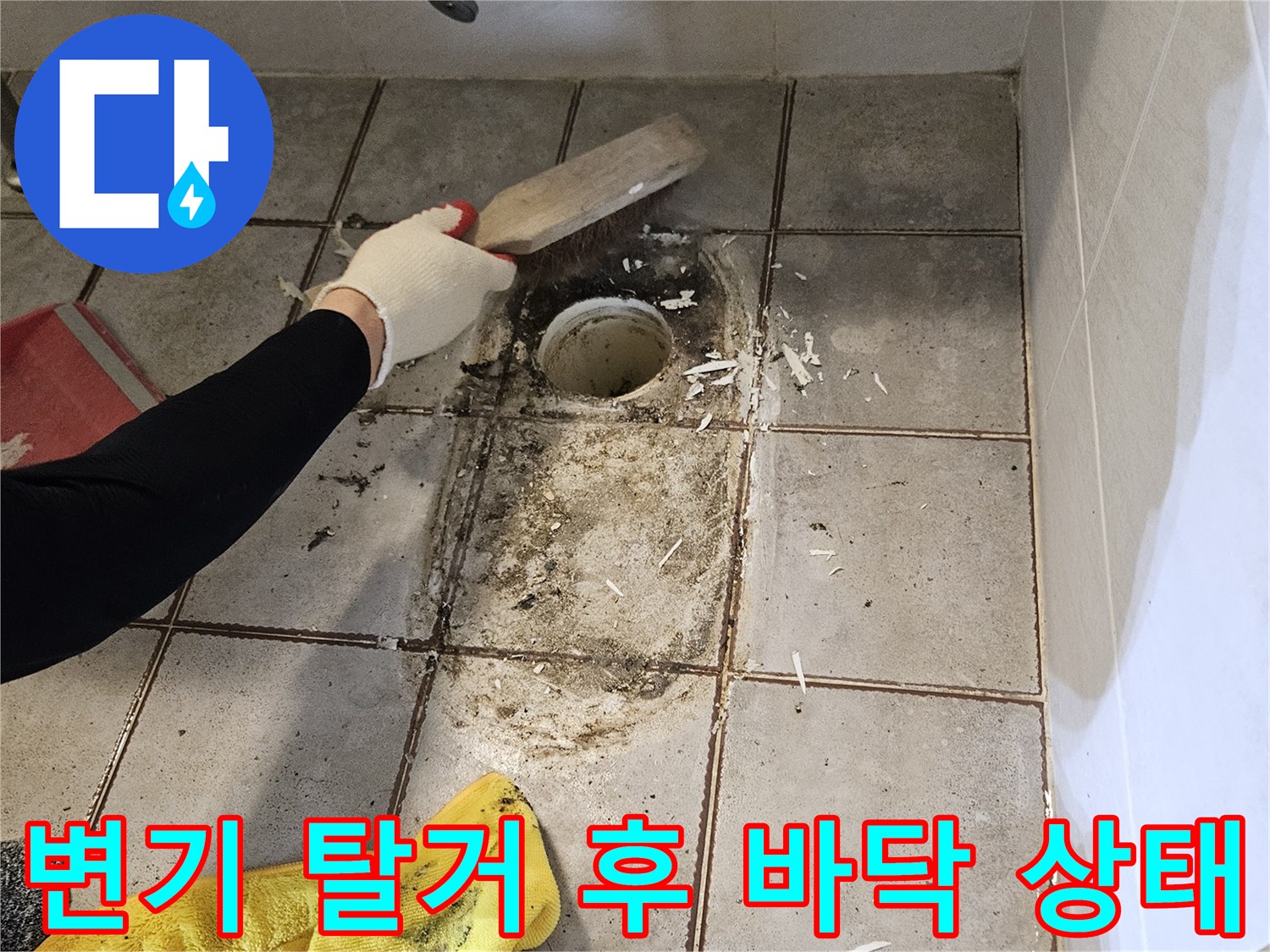 양변기를 제거한 후 드러난 변기 배관과 오염된 타일 바닥 모습