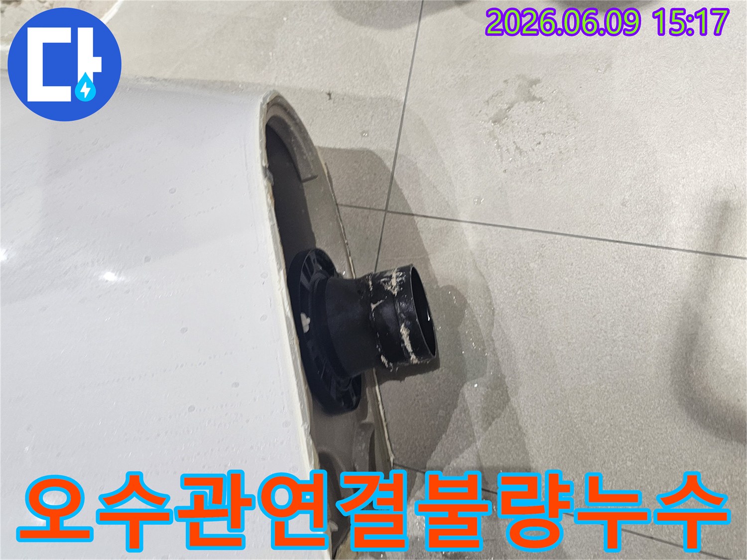 변기 오수관 연결부위의 불량으로 물이 새는 모습-파손된 변기 하부와 젖은 바닥 타일-누수 지점에서 물방울이 떨어지는 현장